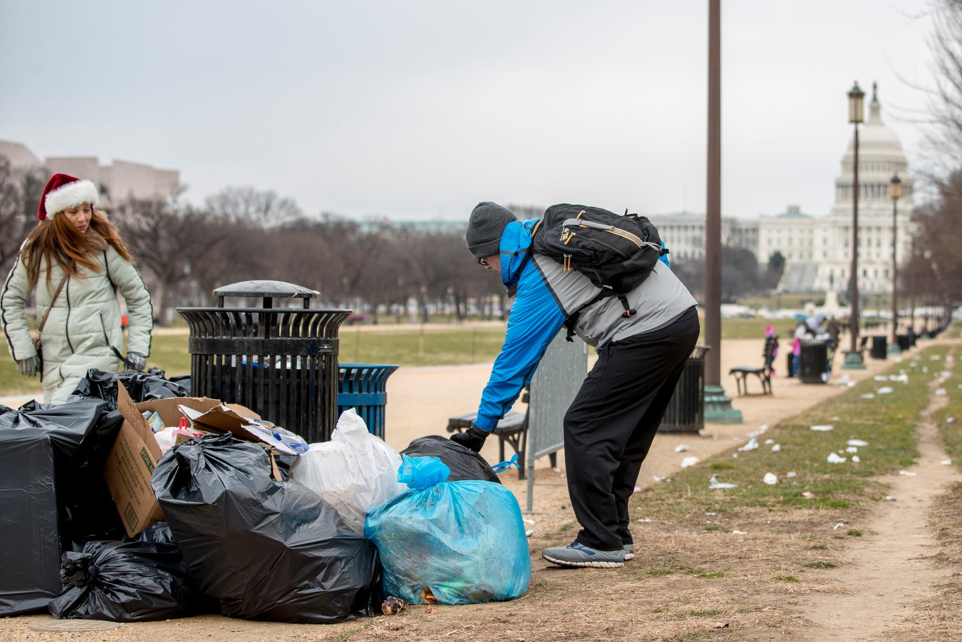 En frivilig tar hans om sopor vid grönområdet National Mall i USA:s huvudstad Washington DC. I bakgrunden syns kongressbyggnaden Capitolium, där en eventuell budgetuppgörelse om att öppna statsapparaten måste godkännas.