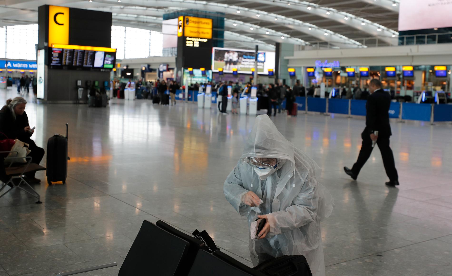 Resenärer på Heathrow i London tidigare i år som skyddar sig från coronaviruset med mask och skyddskläder. Arkivbild.