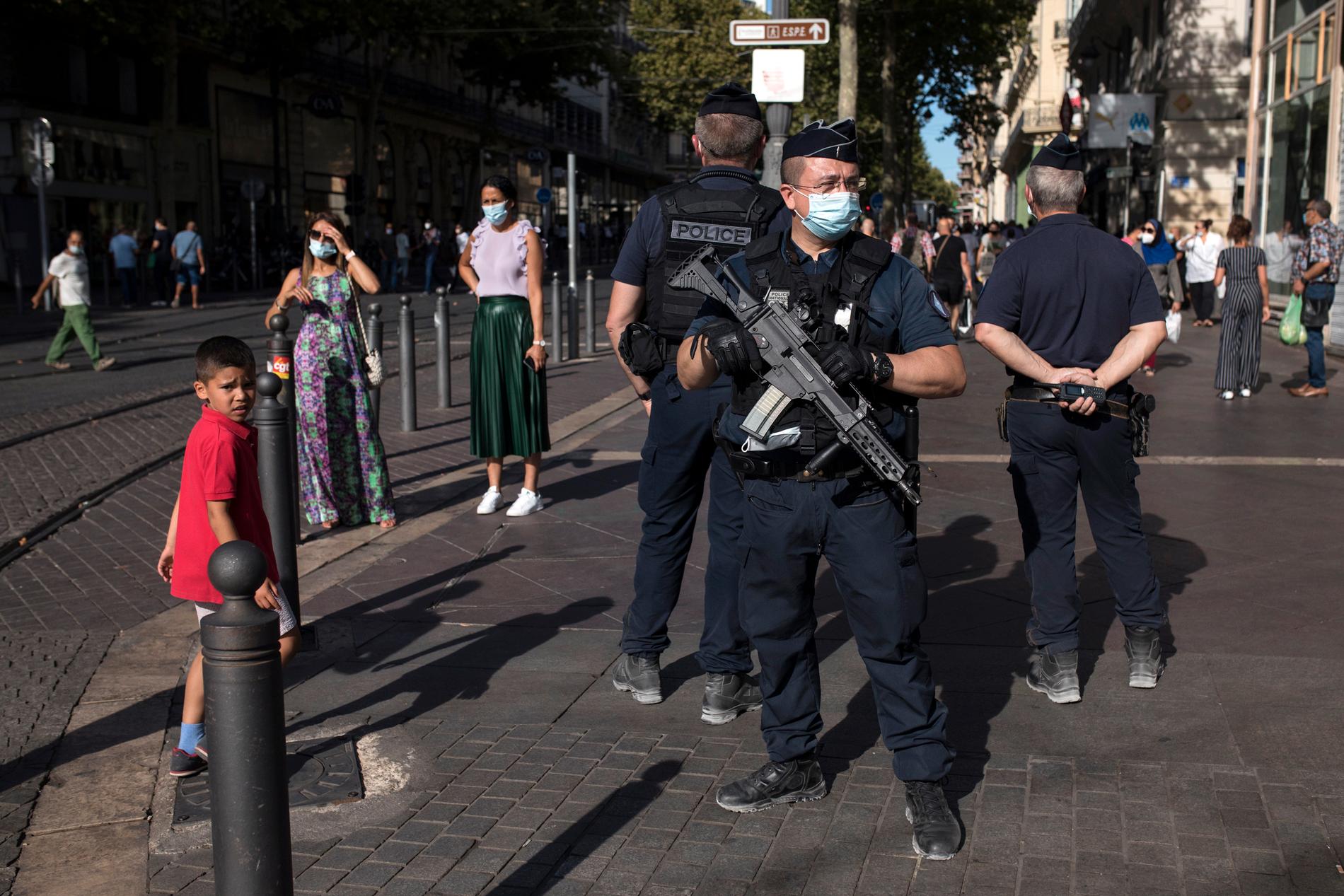 Poliser med munskydd patrullerar gatorna i Marseille.