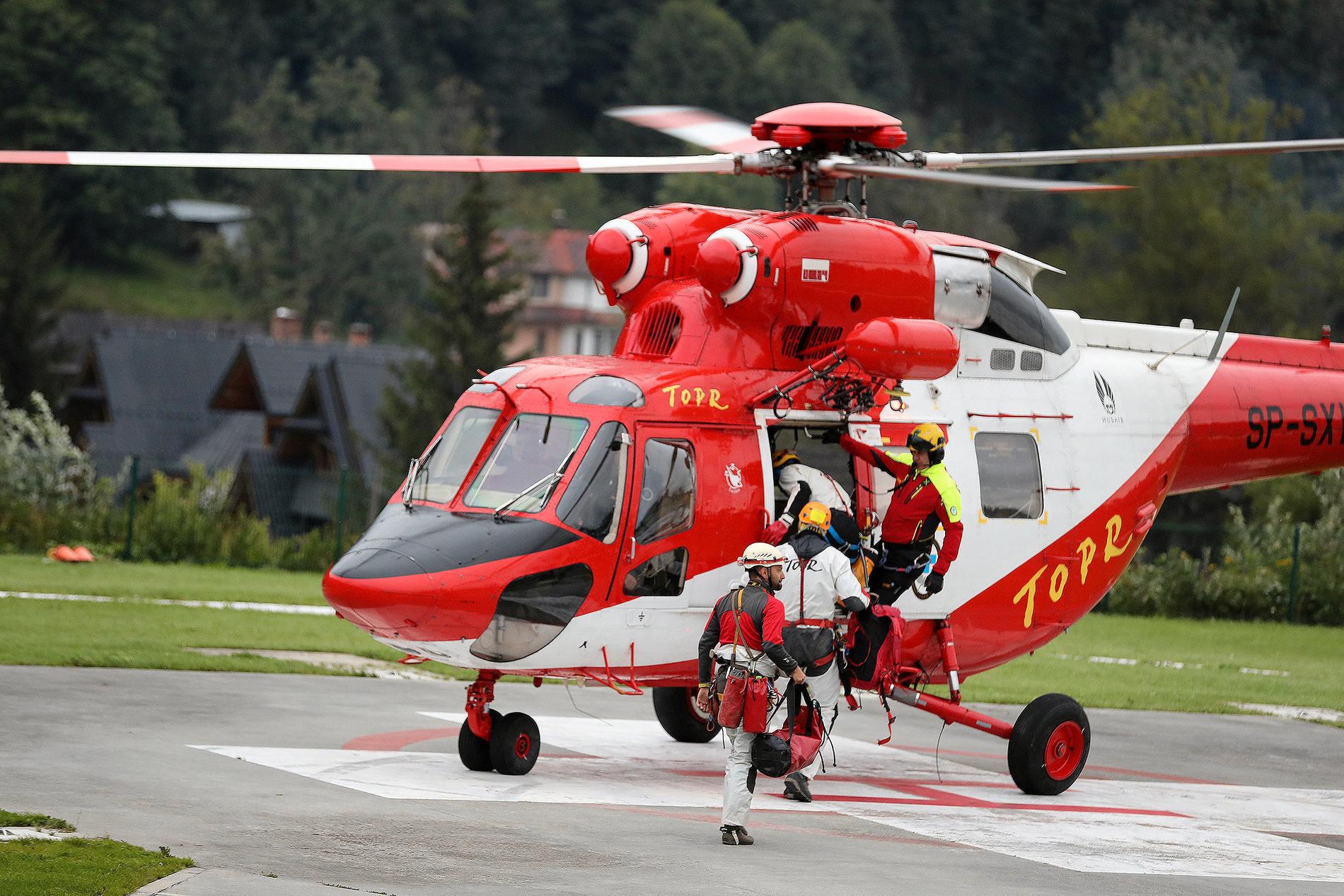 Räddningsarbetare går ombord på en helikopter för att delta i insatsen.