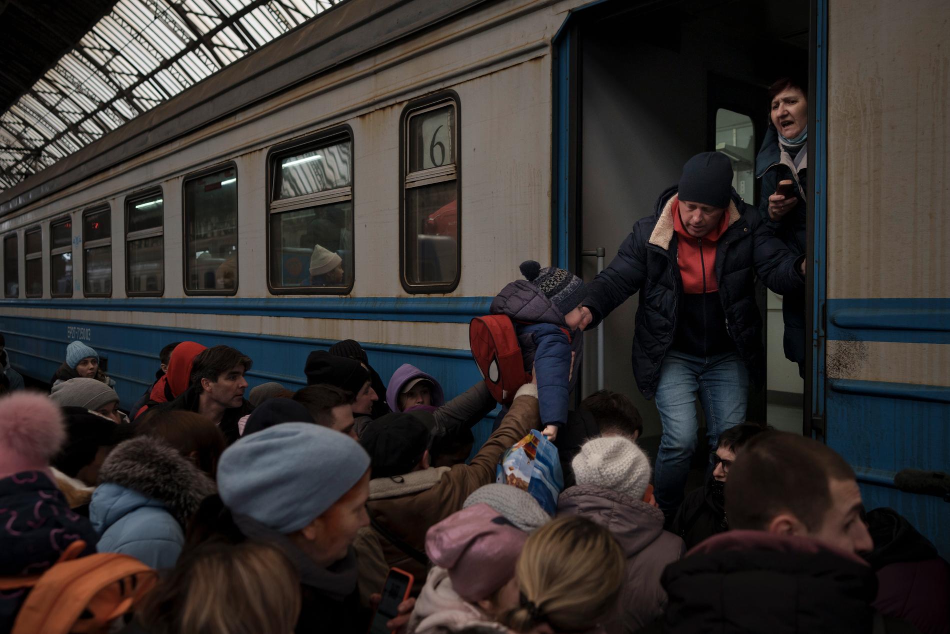 Människor försöker desperat ta sig ombord på ett tåg mot Slovakien från Lviv. 