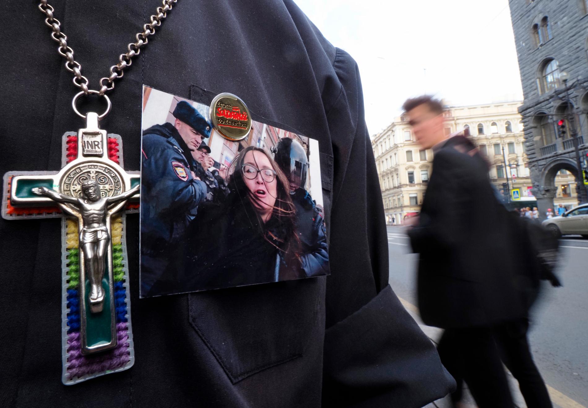 En person bär mördade Jelena Grigorjevas bild på skjortuppslaget under en sorgemanifestation i Sankt Petersburg. Arkivbild.