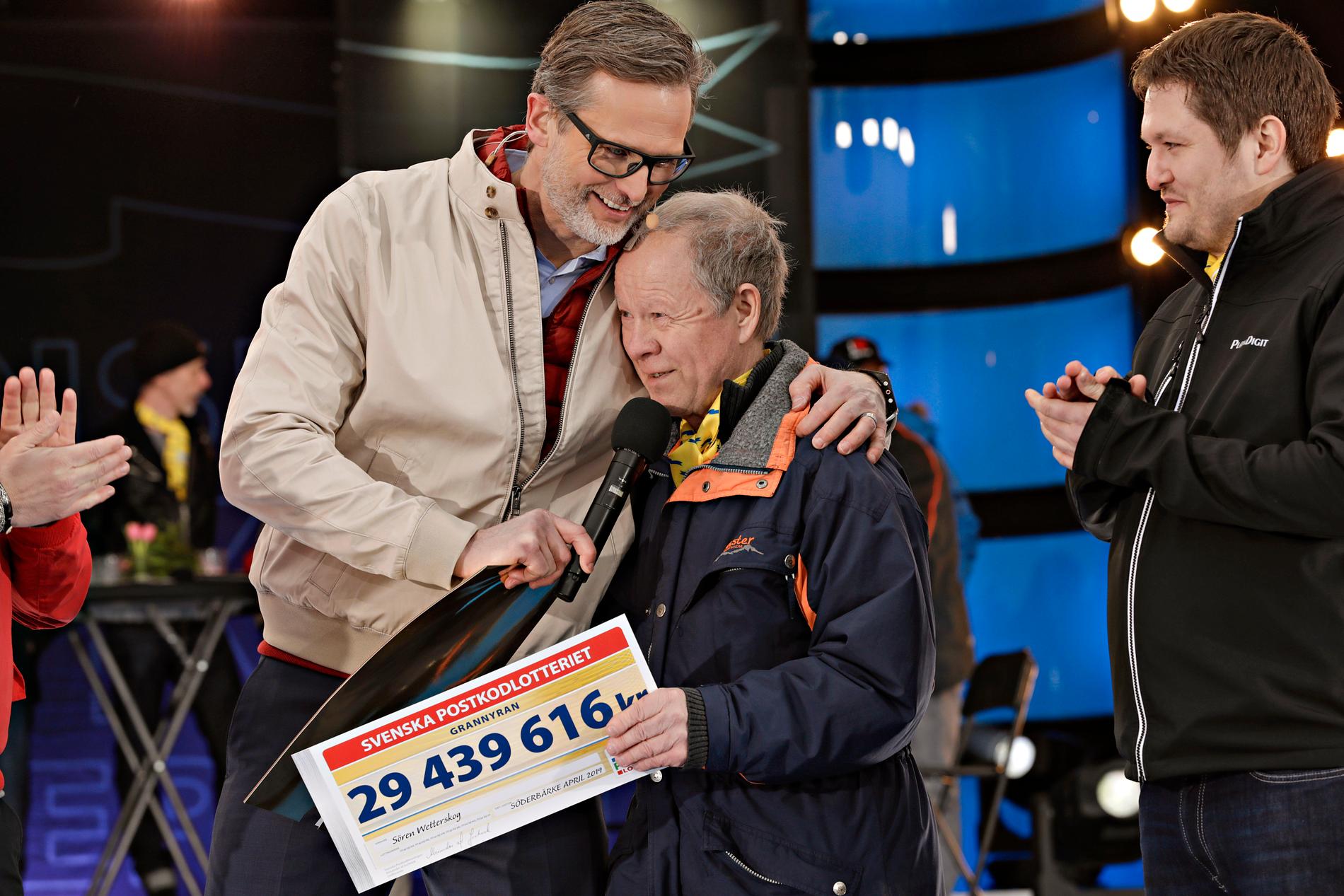 Sören Wetterskog från Söderbärke kan knappt tro sina ögon när han öppnat checken i Postkodlotteriets grannyra och får en kram av programledaren Rickard Sjöberg.