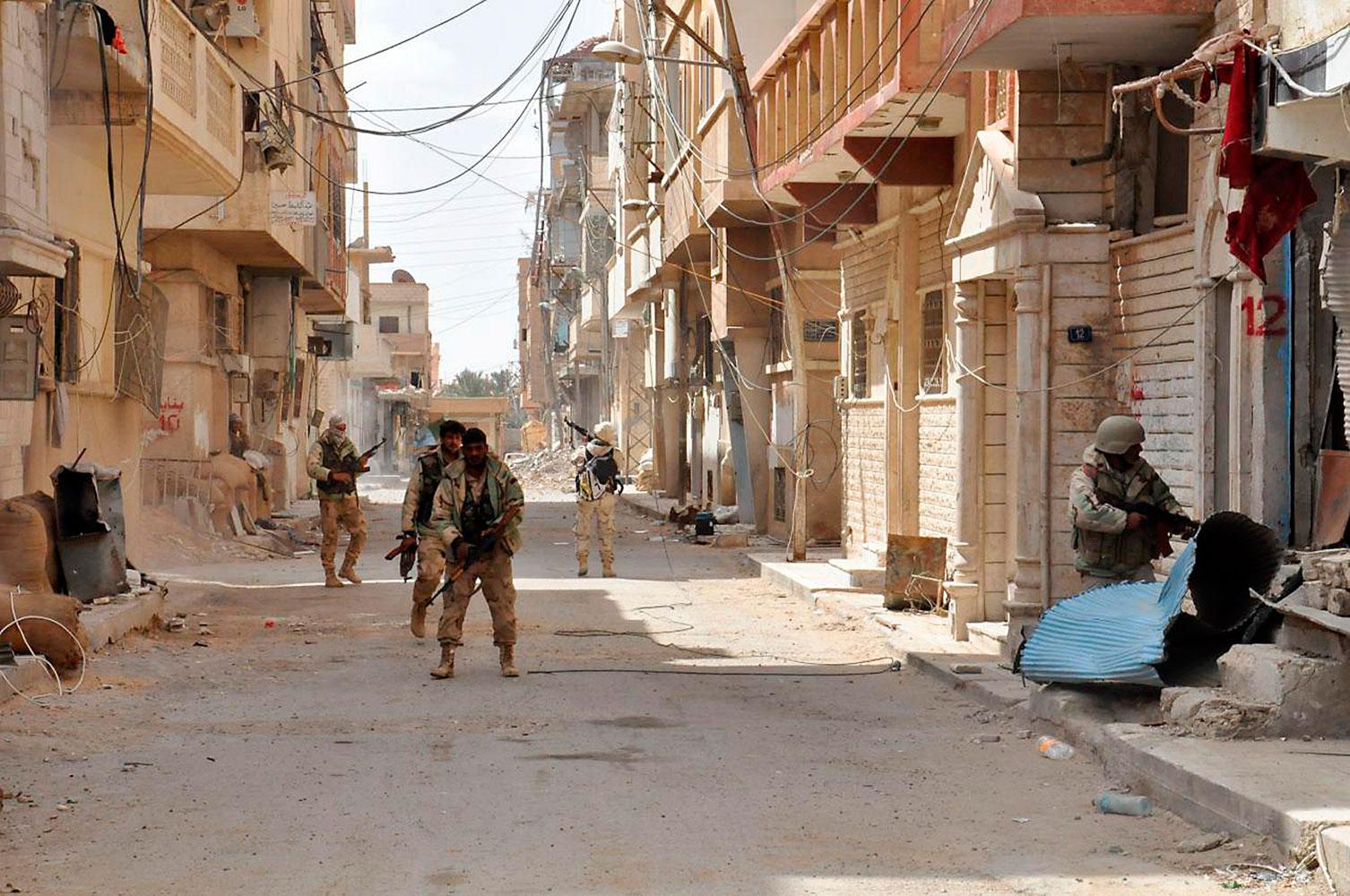 Soldater lojala till den syriska regimen patrullerar gator i moderna Palmyra. Bilden har tagits av den syriska regimen.