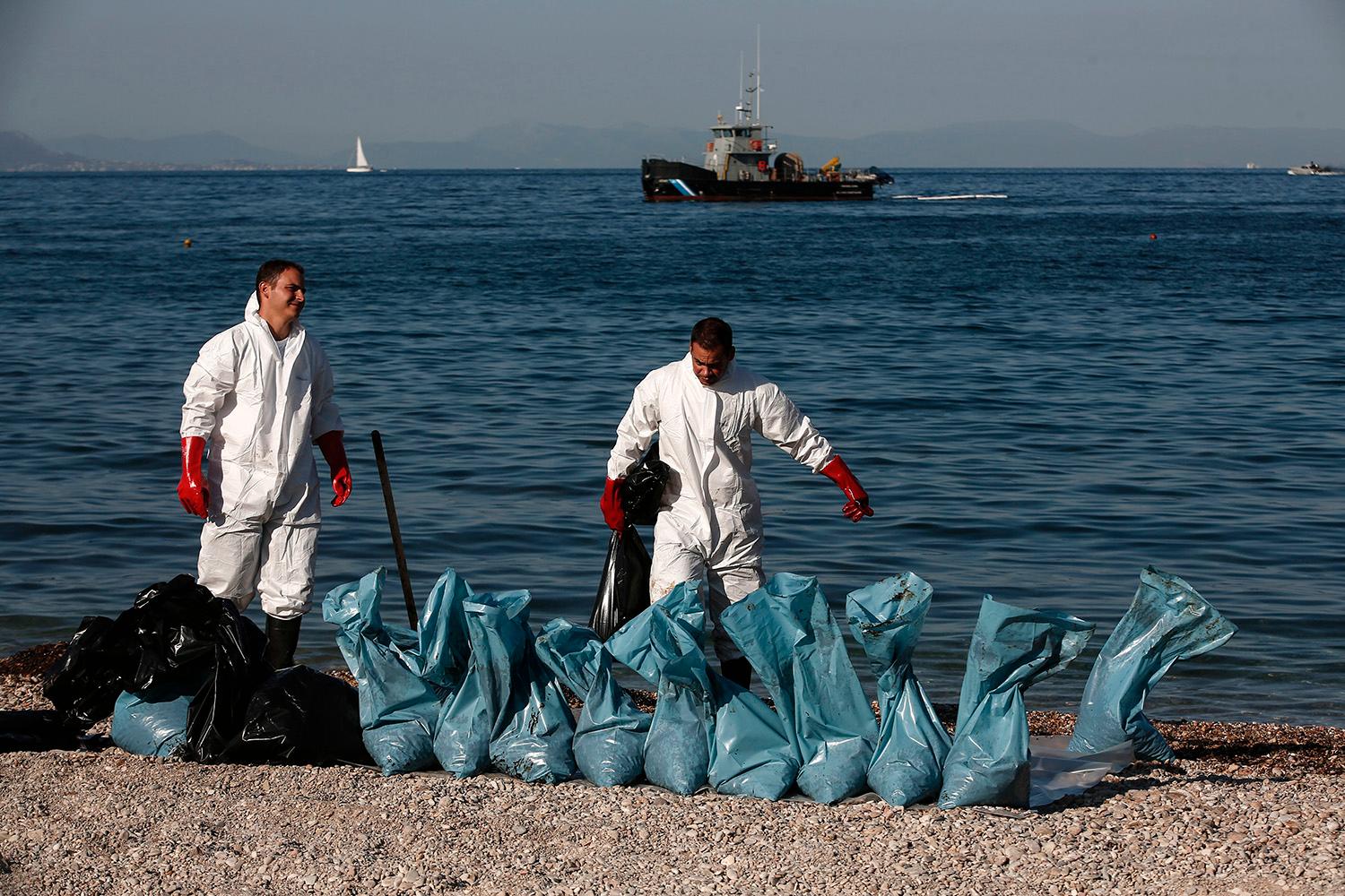 Arbetet pågår med att rensa stranden från olja. Glyfada, Grekland. 