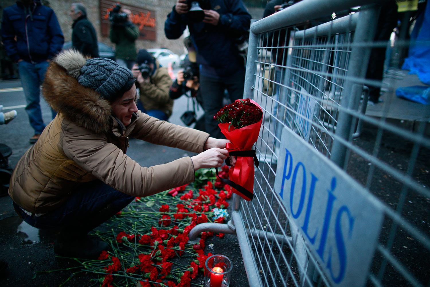 En kvinna lämnar en bukett med rosor utanför nattklubben i Istanbul.