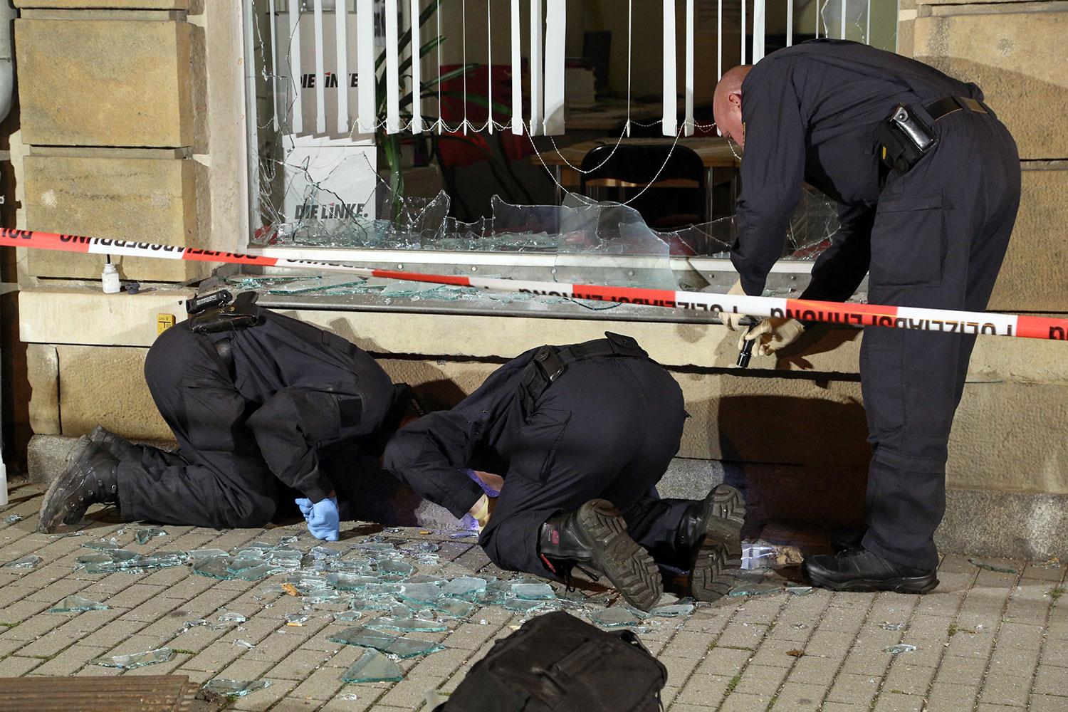 Poliser undersöker utanför ett kontor tillhörande vänsterpartiet "Die Linke" efter ett attentat.