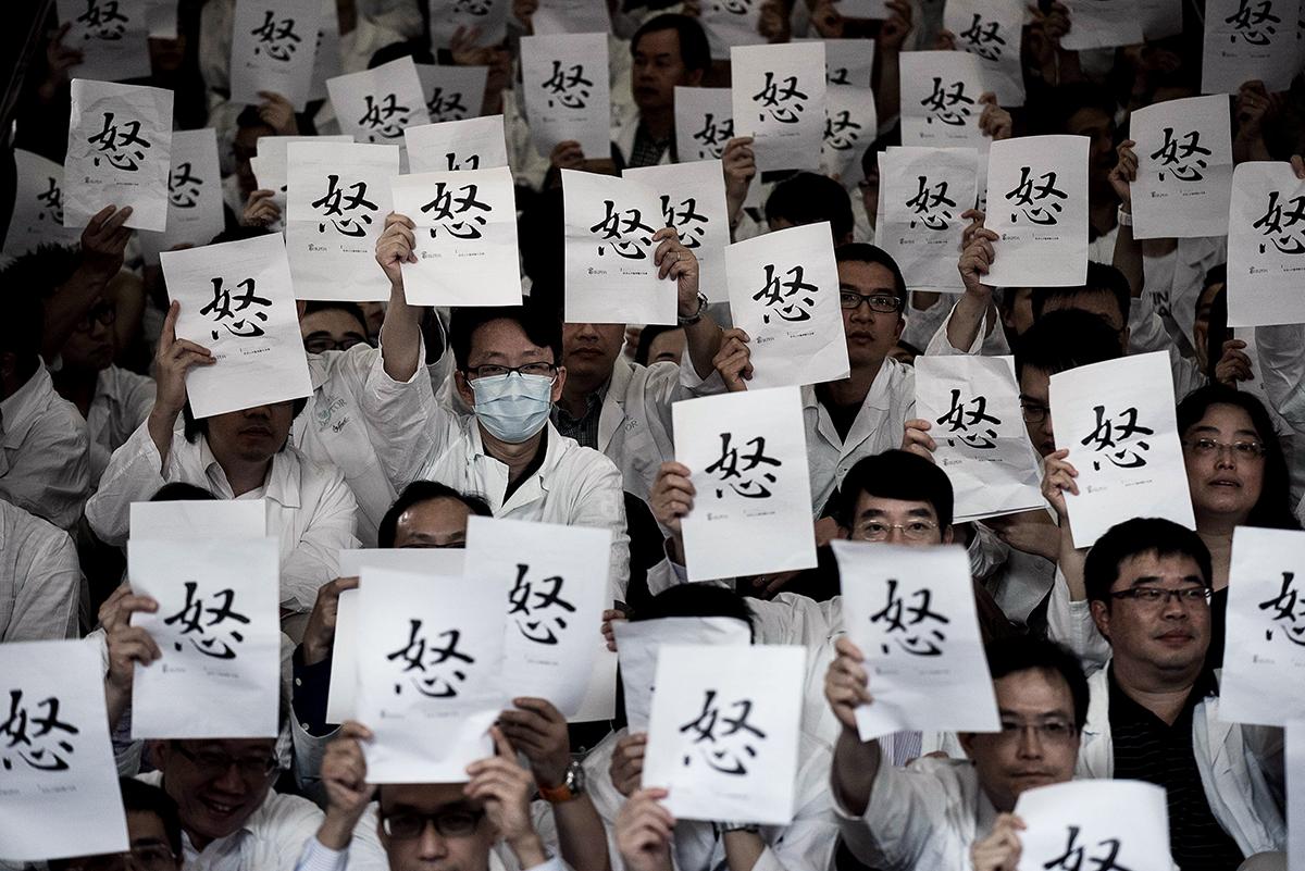 Hong Kong, Kina: Läkare på Drottning Elisabeths sjukhus i Hong Kong protesterar sedan de nekats löneförhöjningar som matchar dem i den privata sektorn.