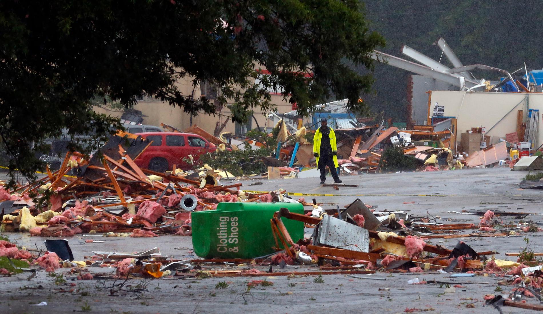 En polis vaktar platsen där flera byggnader förstördes i Fairfield, Alabama, i vad som tros vara en tornado i stormen Cindys spår.