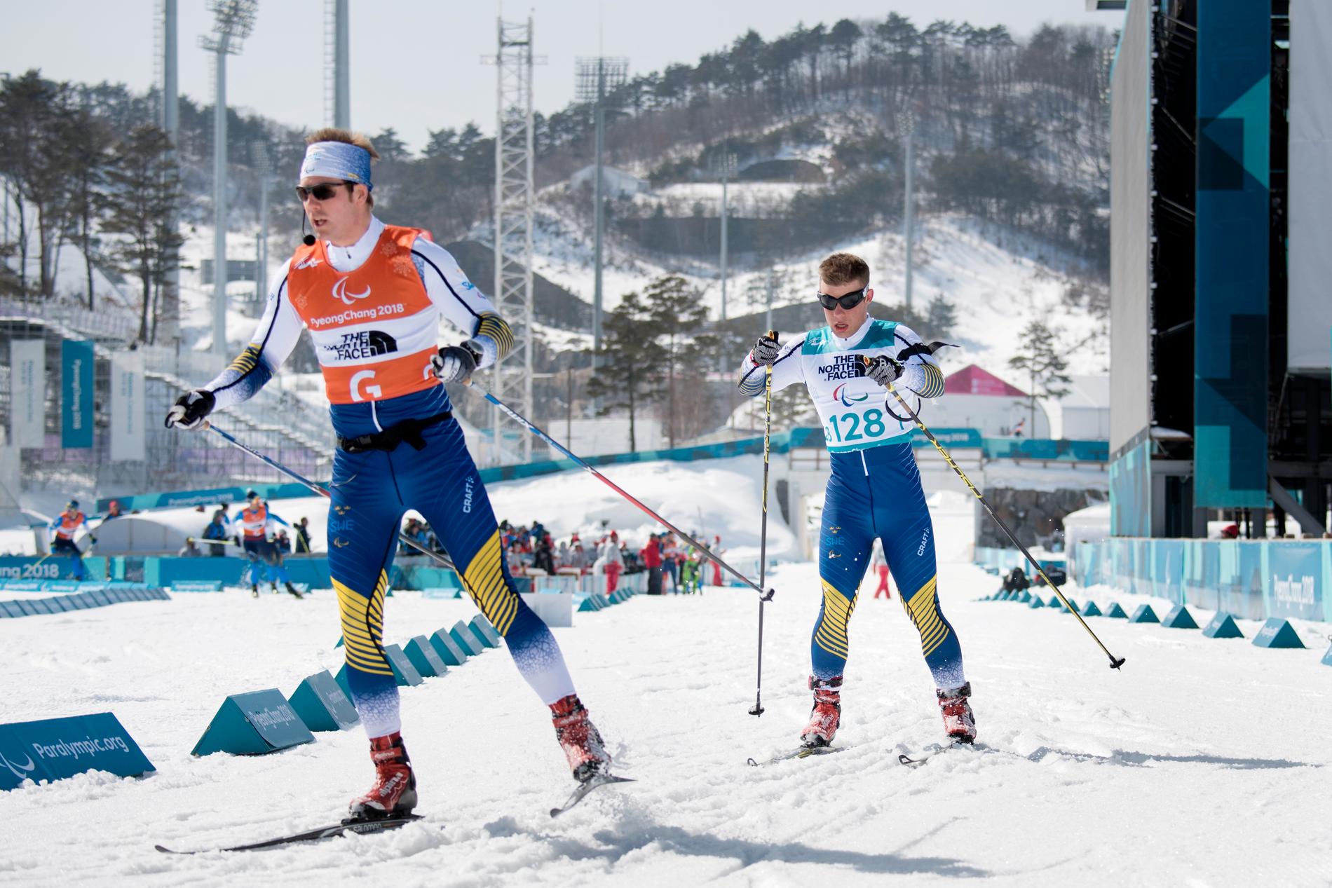 Zebastian Modin, med guiden Johannes Andersson framför sig i spåret, slutade på sjunde plats i skidskyttesprinten i Paralympics.