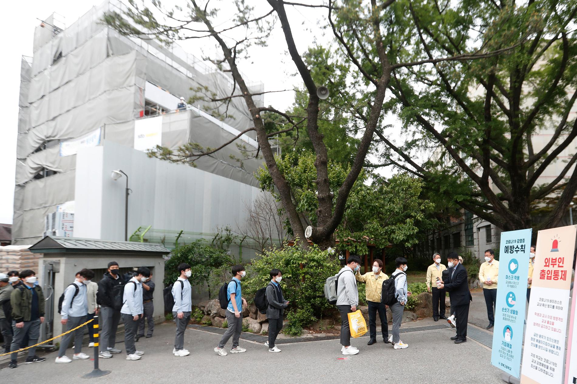 Elever köar för att få sin kroppstemperatur kontrollerad vid en skola i Seoul.