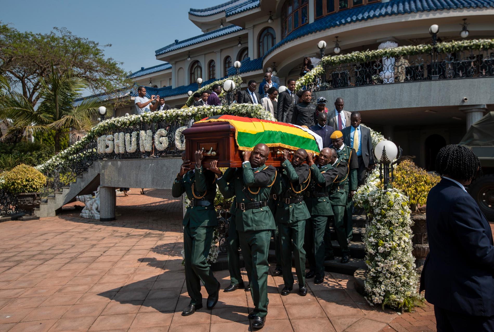 Robert Mugabes kista bärs från den avlidne expresidentens residens i Harare till en helikopter på fredagen, för vidare transport till en arena där kroppen ska ligga på lit de parade.