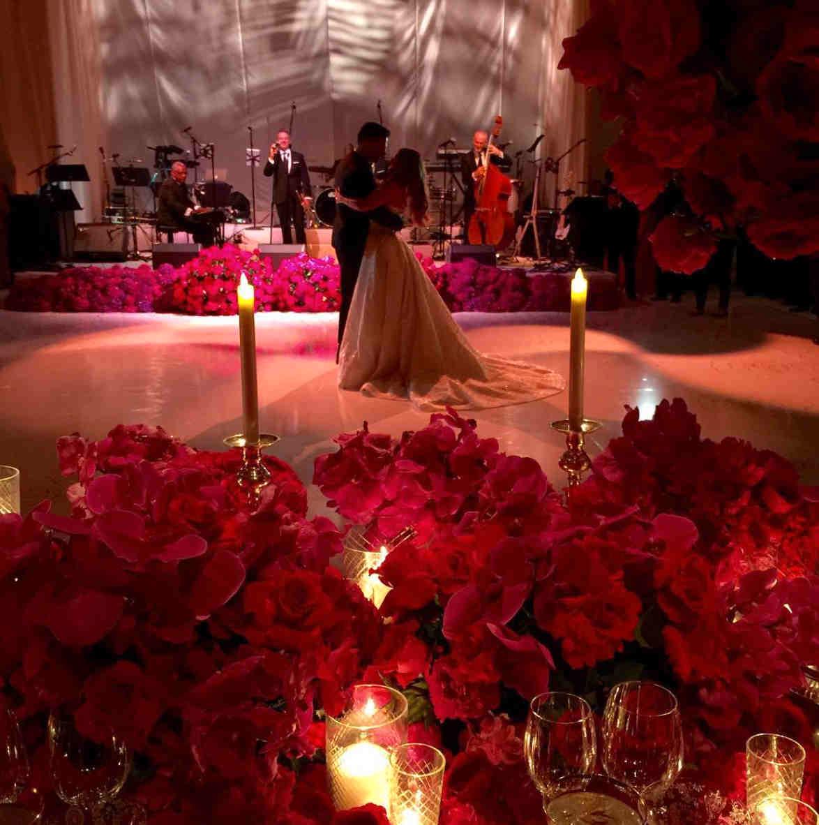 Världens vackraste par dansar bröllopsvals i ett rum fyllt av jättefina blommor.
