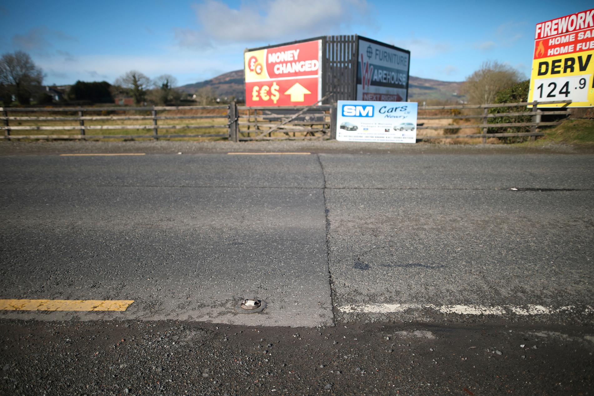 Allt som syns av den tidigare gränsen mellan republiken Irland och Nordirland här är färgen på vägmarkeringarna. Frågan om en ny "hård gräns" på den irländska ön har visat sig vara den hårdaste brexitnöten att knäcka.