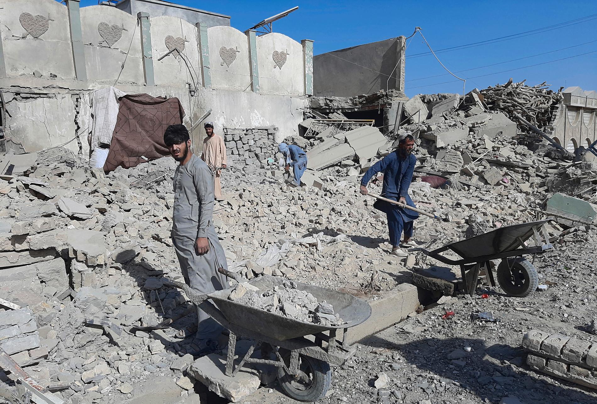 Afghaner inspekterar en skadad byggnad efter luftangreppen mot Lashkar Gah i provinsen Helmand, söder om Kabul. 