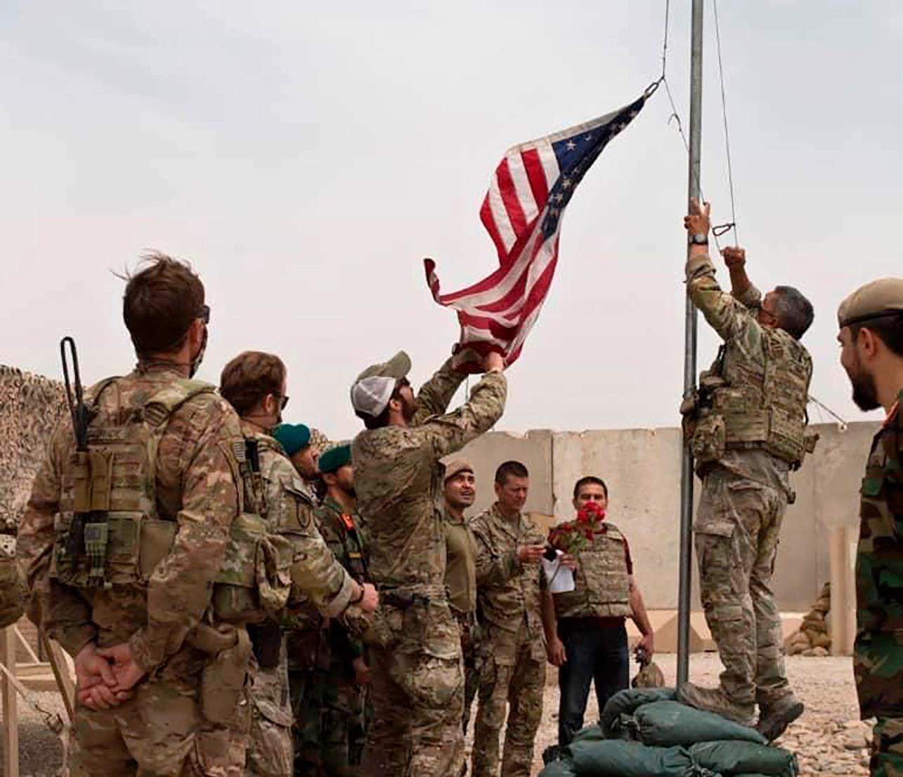Den amerikanska flaggan halas i samband med att den amerikanska armén lämnar över en militärbas till den afghanska armén i provinsen Helmand, söndagen den 2 maj.