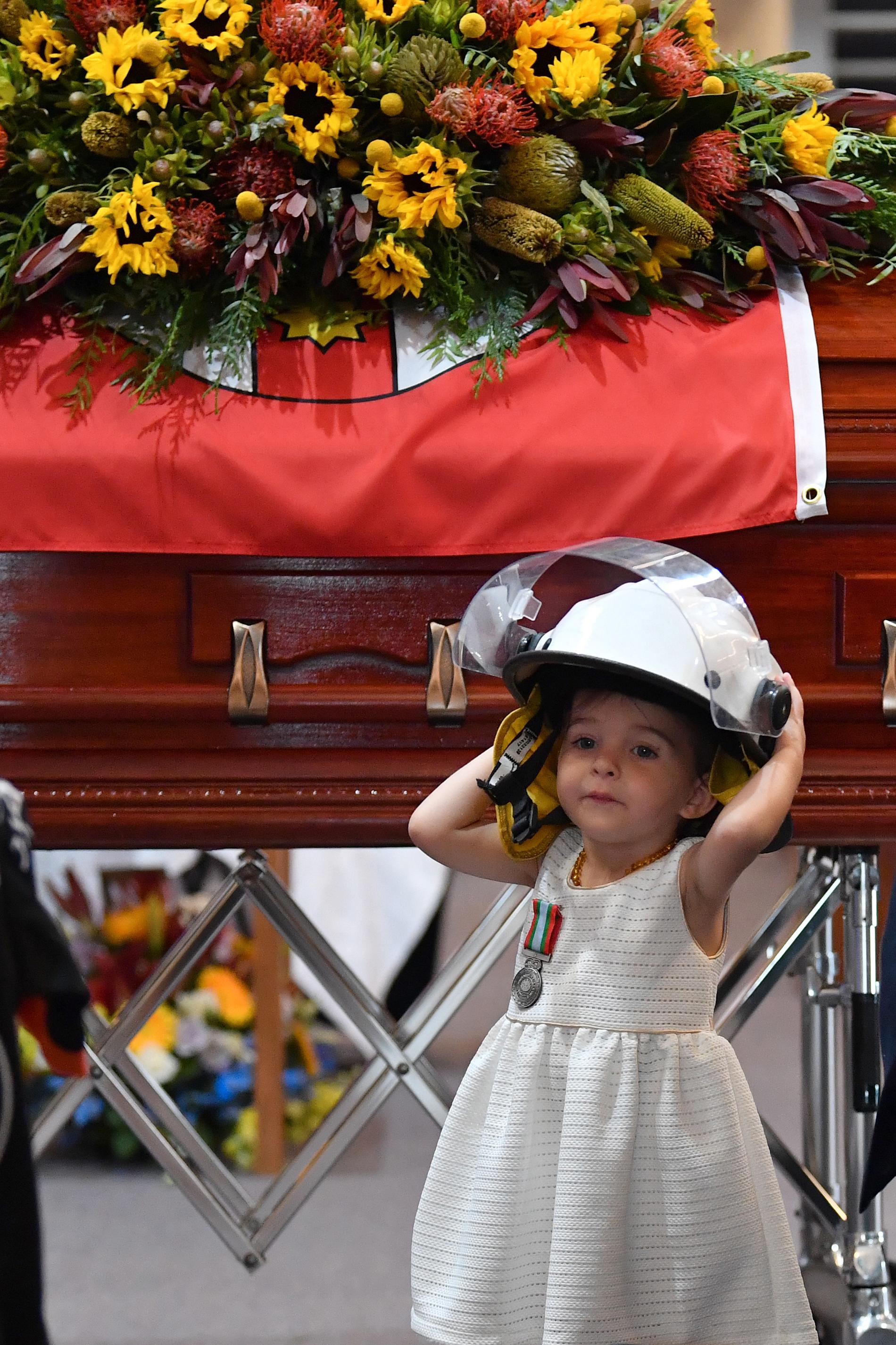 Charlotte bar pappas hjälm på begravningen.