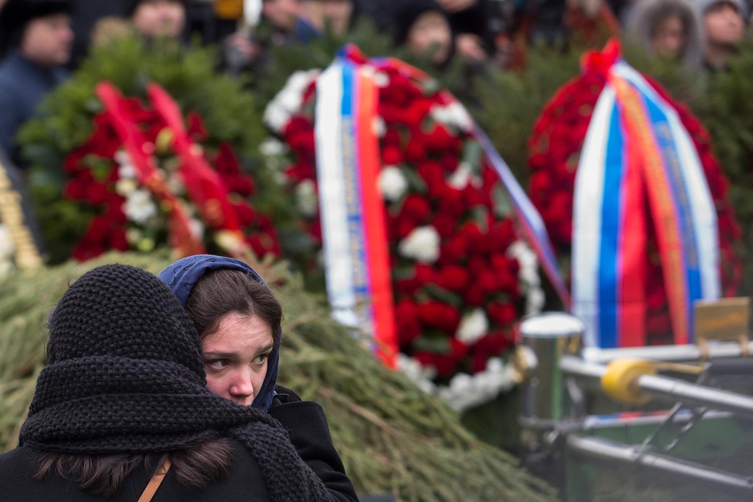En kvinna tröstar Boris Nemtsovs dotter.