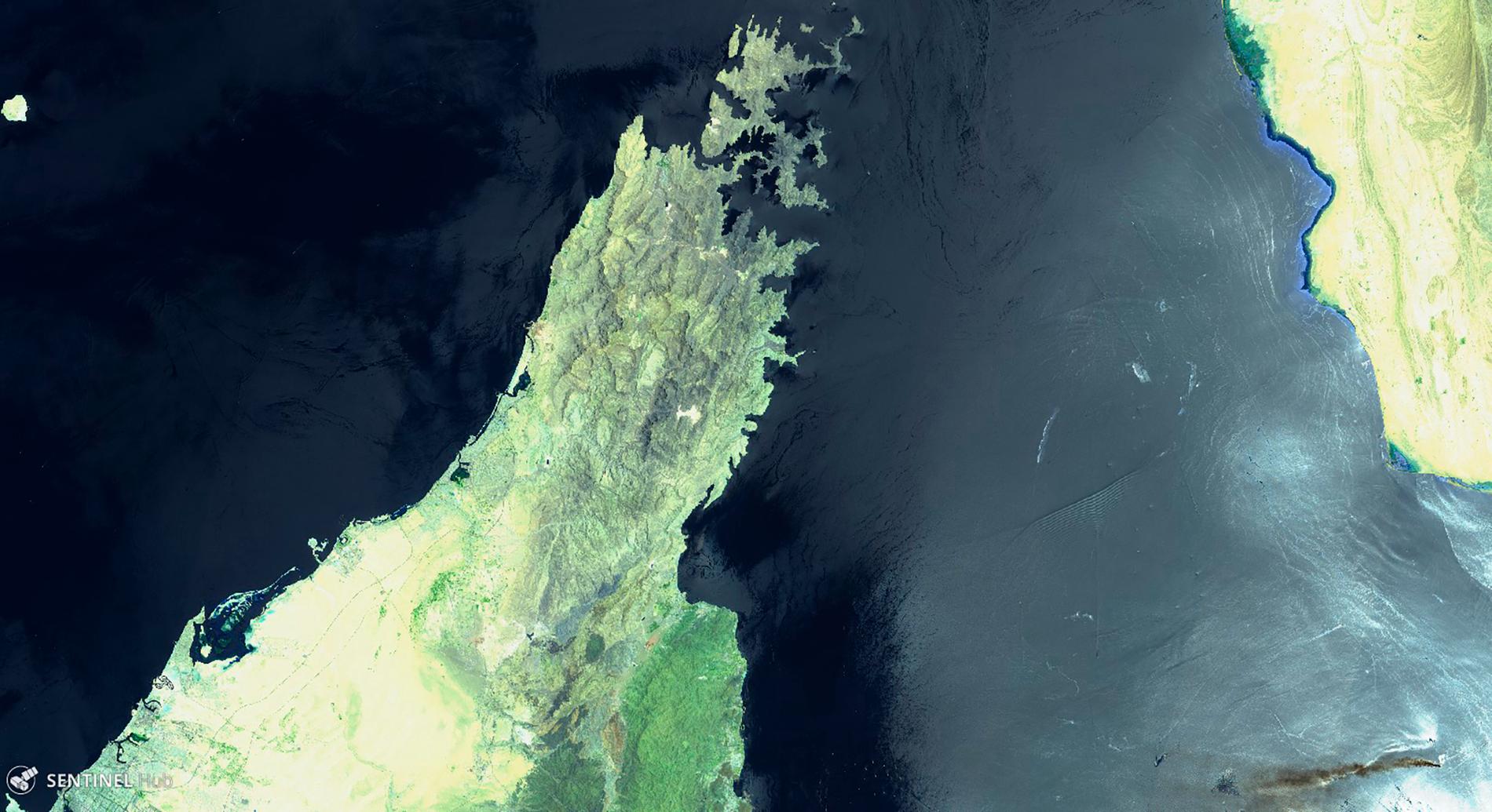 En bild tagen av en EU-satellit visar hur rök sprids i Hormuzsundet från branden ombord på det norskägda fartyget MT Front Altair, som syns nere till höger i bild. Musandamhalvön till vänster tillhör Förenade arabemiraten och Oman och landmassan till höger är Iran.