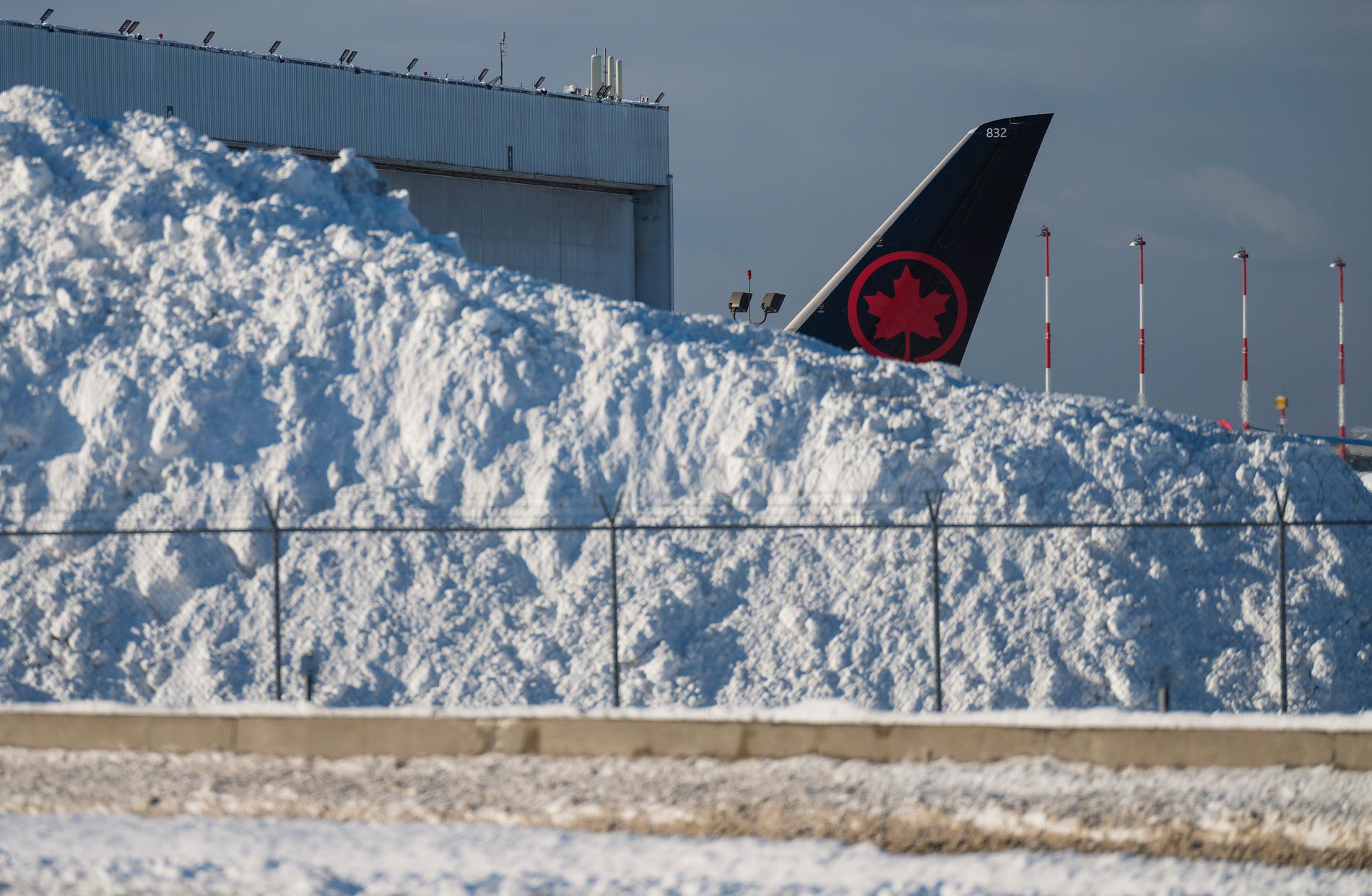 Stjärten på ett Air Canada-flygplan i en snöhög på Vancouver International Airport i Richmond, British Columbia.