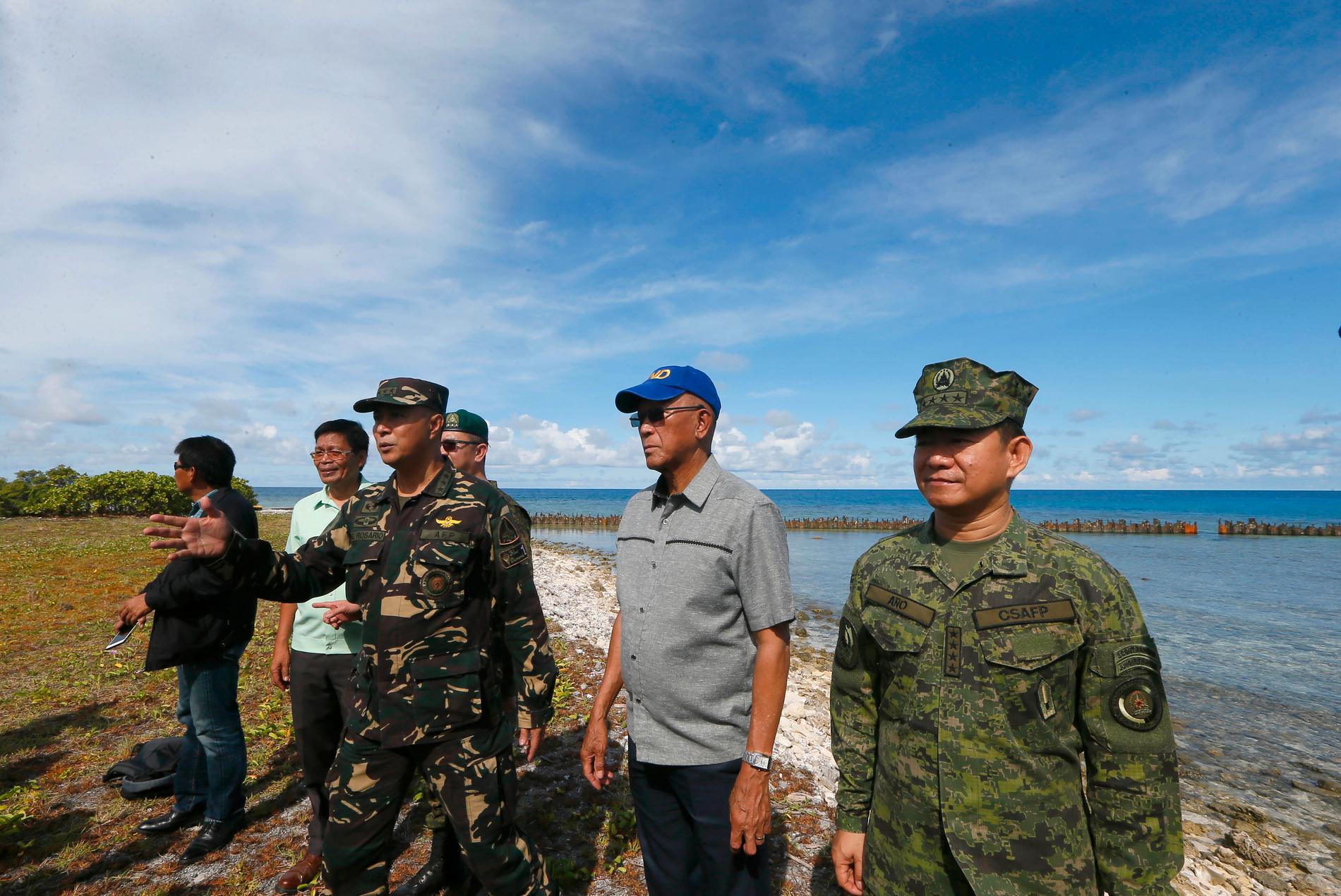 Filippinernas försvarschef Delfin Lorenzana, med andra högt uppsatta militärer, vid en inspektion av ön i Sydkinesiska sjön. Arkivbild.