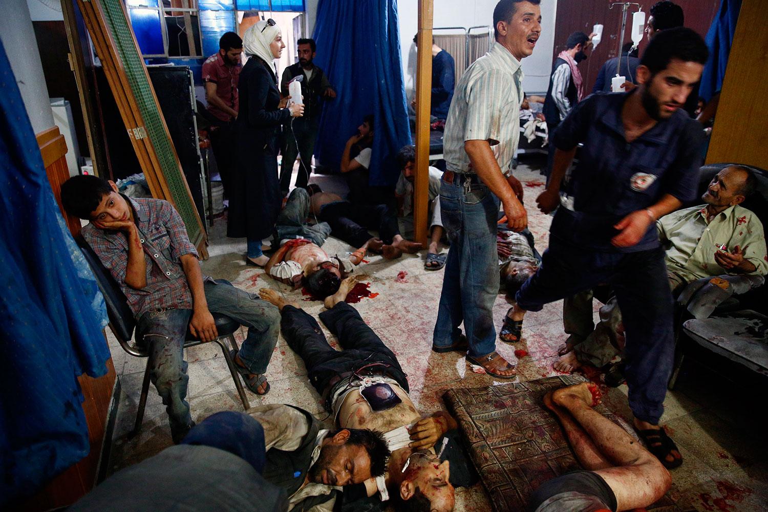 Skadade ligger på golvet i ett provisoriskt sjukhus i Douma.