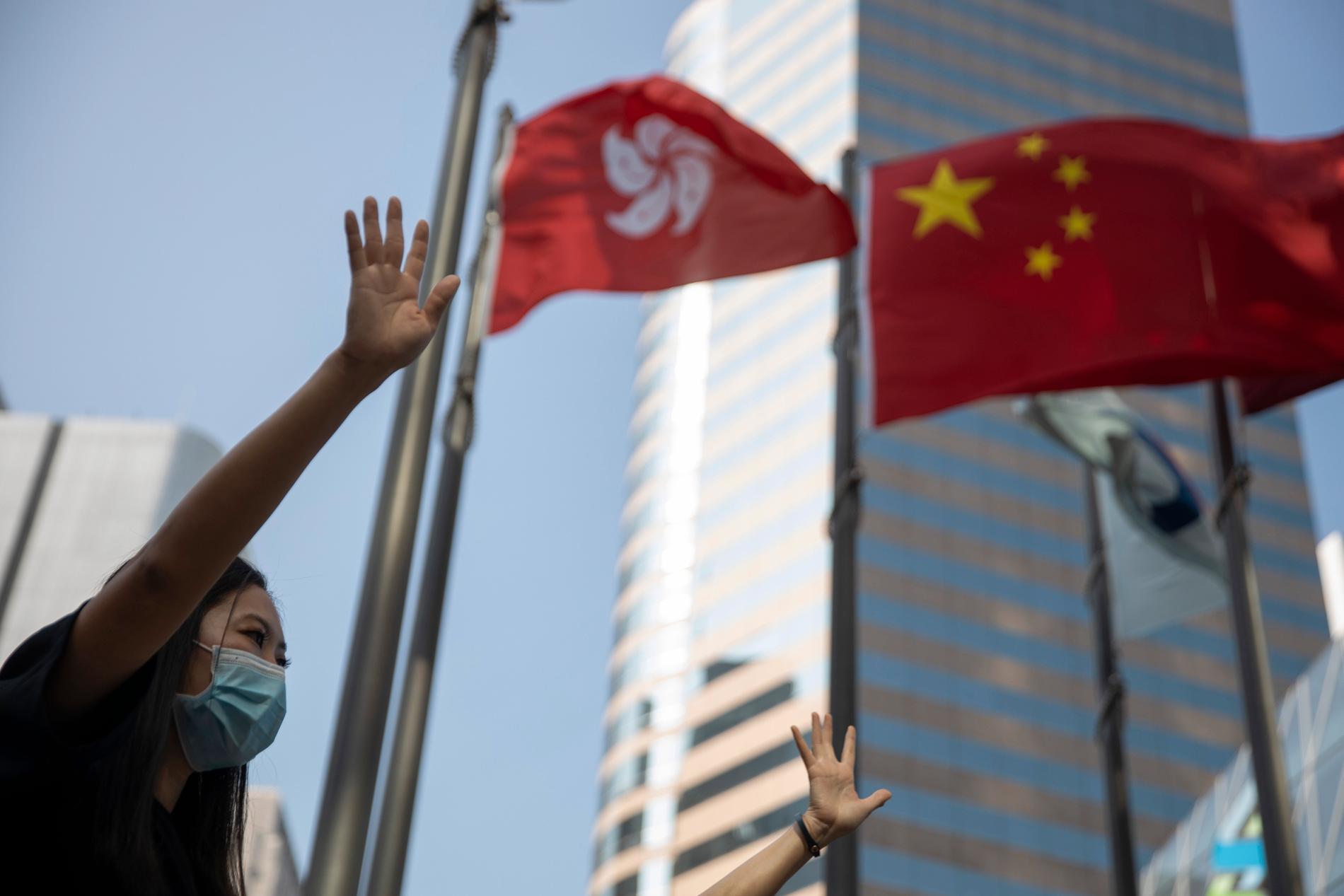 En demonstrant i Hongkong håller upp sin hand med sina fem fingrar som en symbol för de fem krav som demonstranterna ställt på Hongkongs regering.