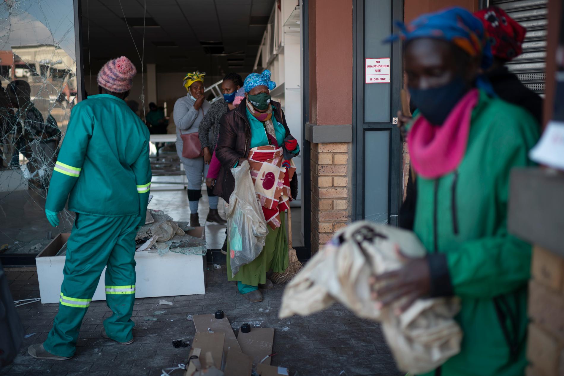 Volontärer röjer upp bråten vid ett köpcentrum som plundrats i sydafrikanska Soweto. Arkivbild.