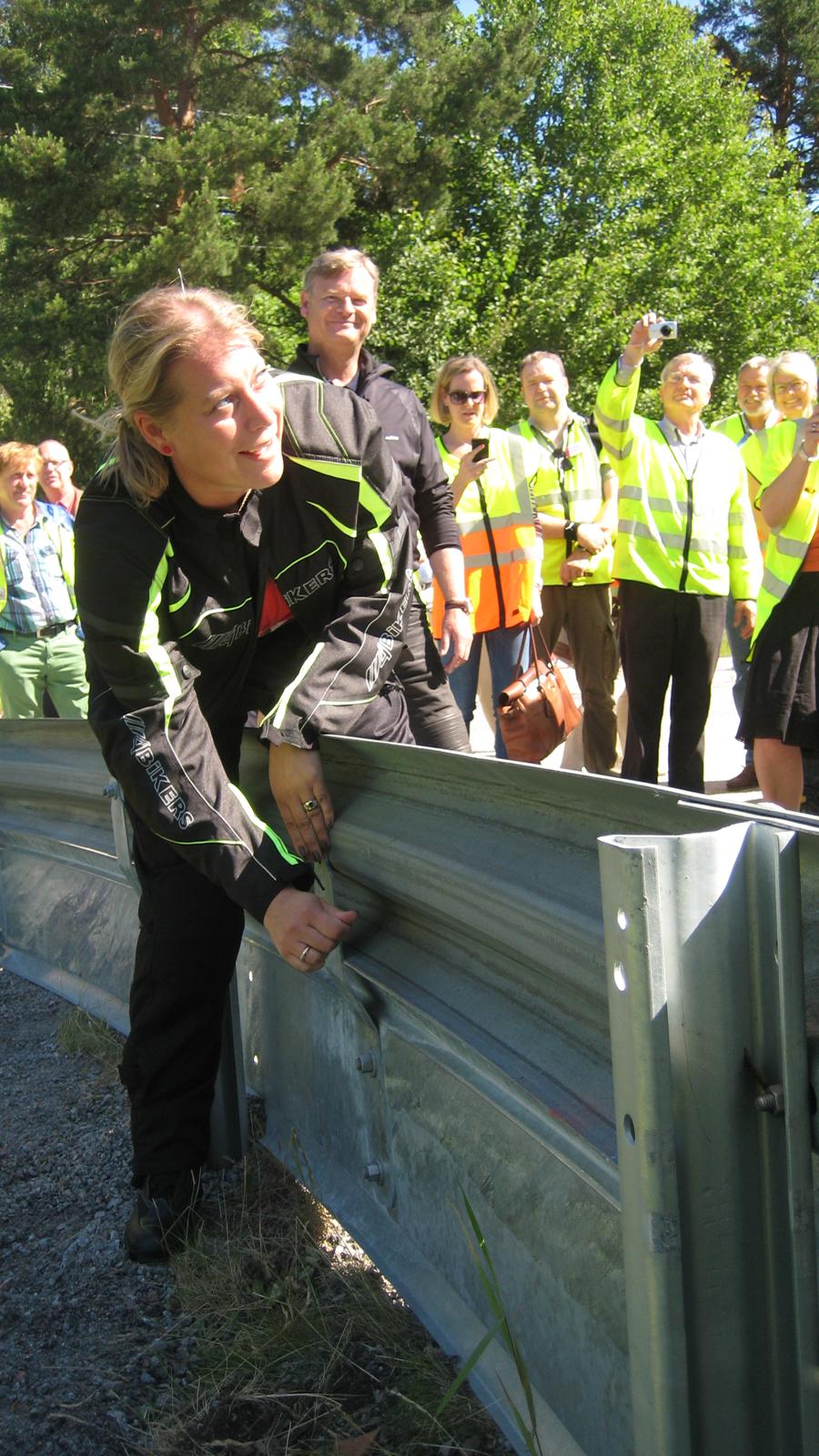 Infrastrukturminister Catharina Elmsäter Svärd drar fast sista bulten i det nya räcket anpassat för motorcyklister.