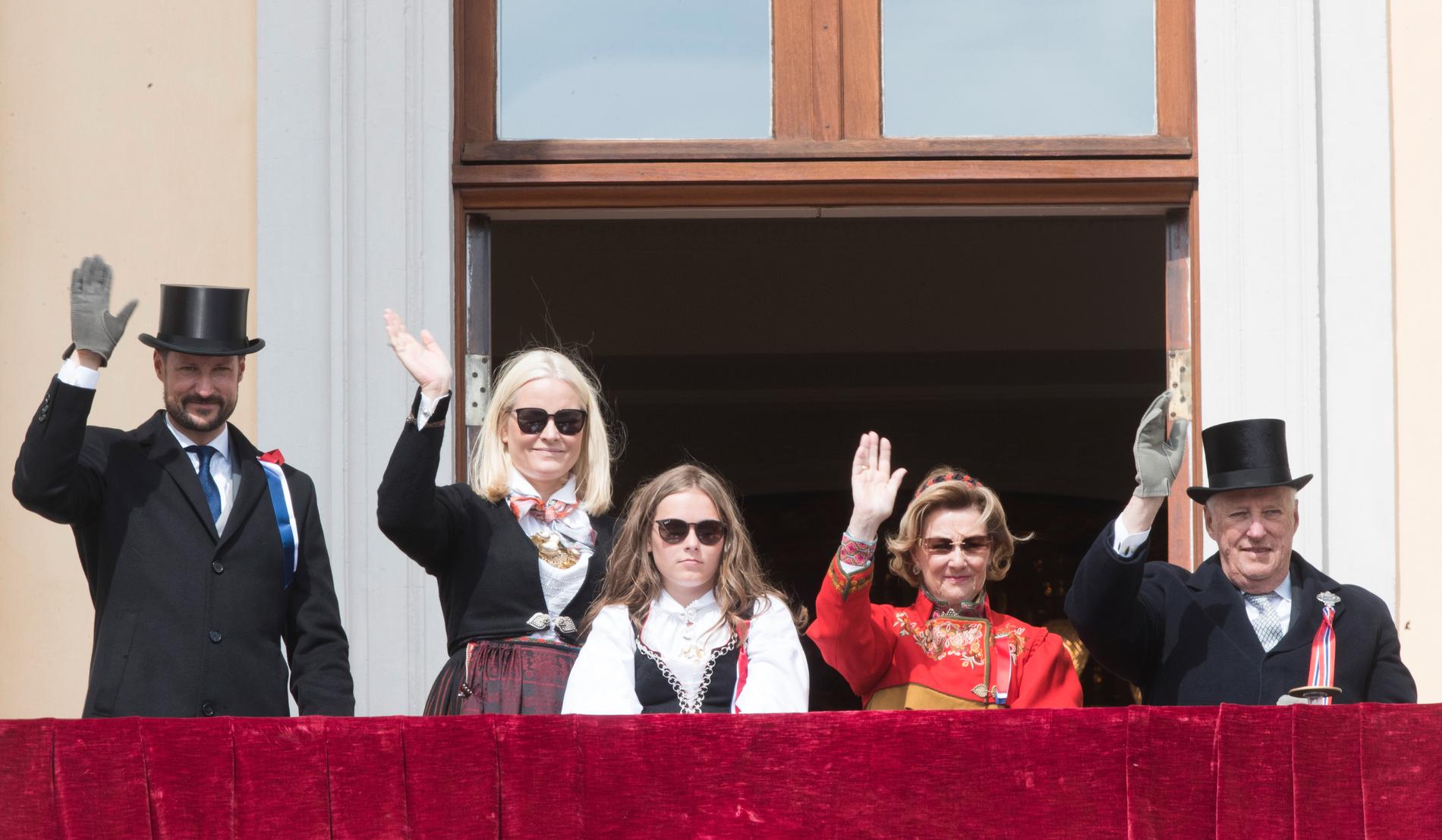 Norska kungafamiljen vinkar från slottsbalkongen. Kung Harald, drottning Sonja, prinsessan Ingrid Axleandra, kronprinsessan Mette-Marit och kronprins Haakon. 