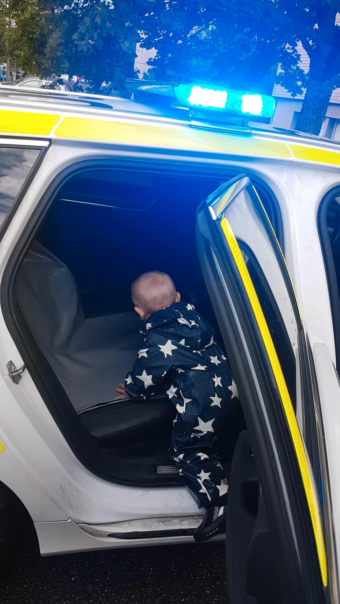 Pojken fick sitta i polisbilen.