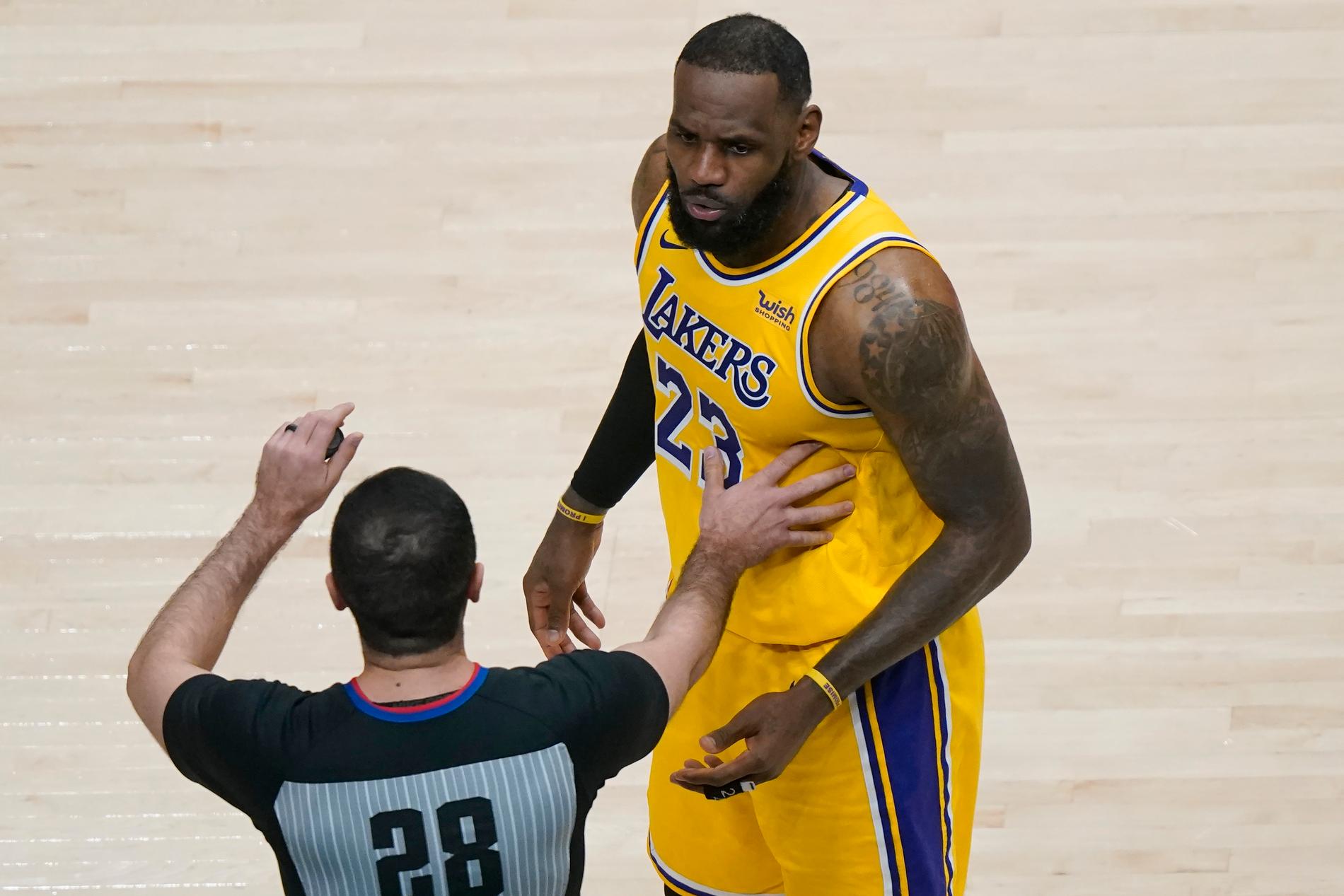 Los Angeles Lakers LeBron James stoppas av domaren när han reagerar på en supporterkommentar.