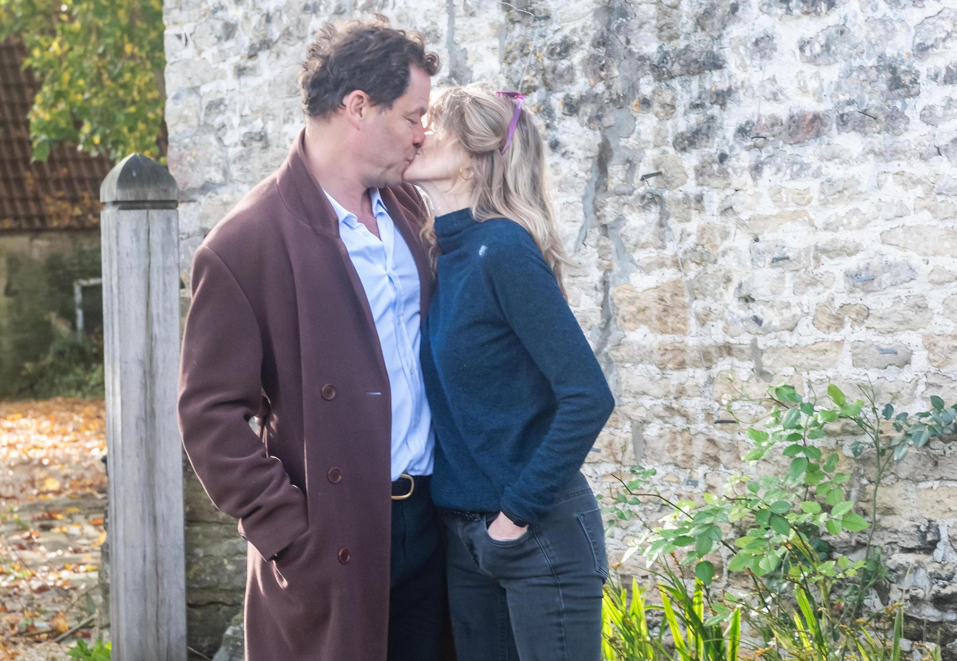 Dominic West och frun Catherine FitzGerald kysser varandra framför fotograferna utanför sitt hem. 