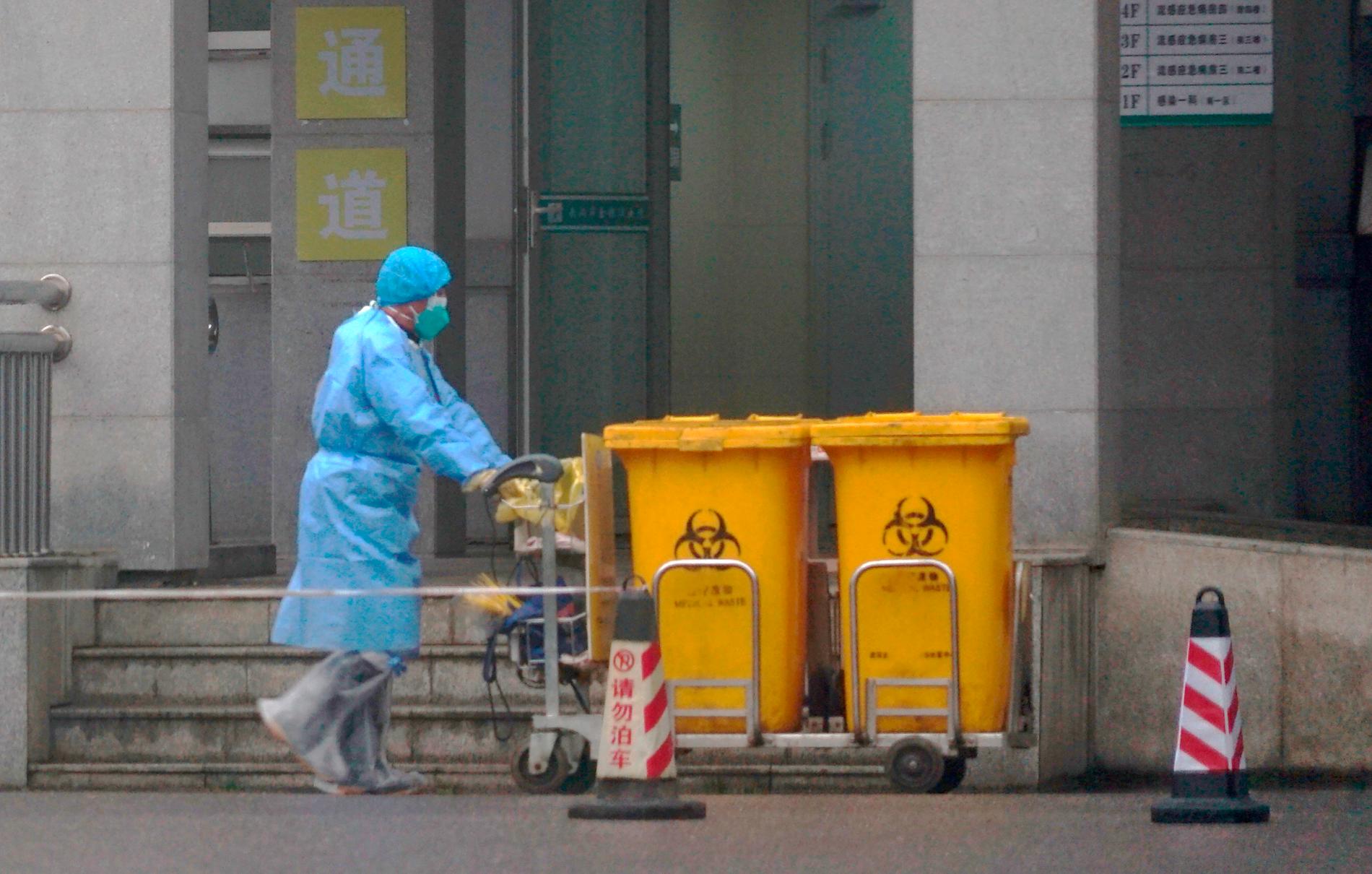 En anställd på ett sjukhus i Wuhan i Kina tar hand om farligt avfall. På sjukhuset behandlas flera personer smittade av coronaviruset. 
