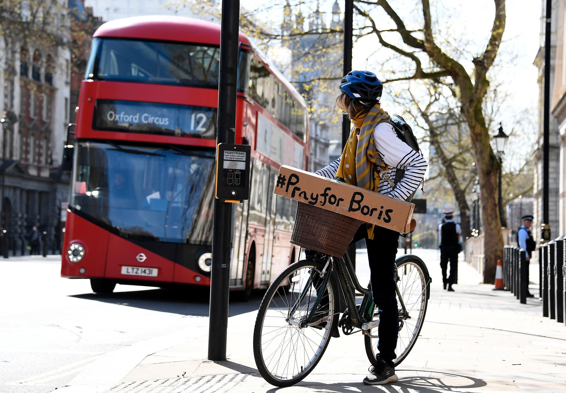 En brittisk cyklist med budskapet "be för Boris" syns i London dagen efter beskedet om att landets premiärminister intensivvårdas för covid-19.
