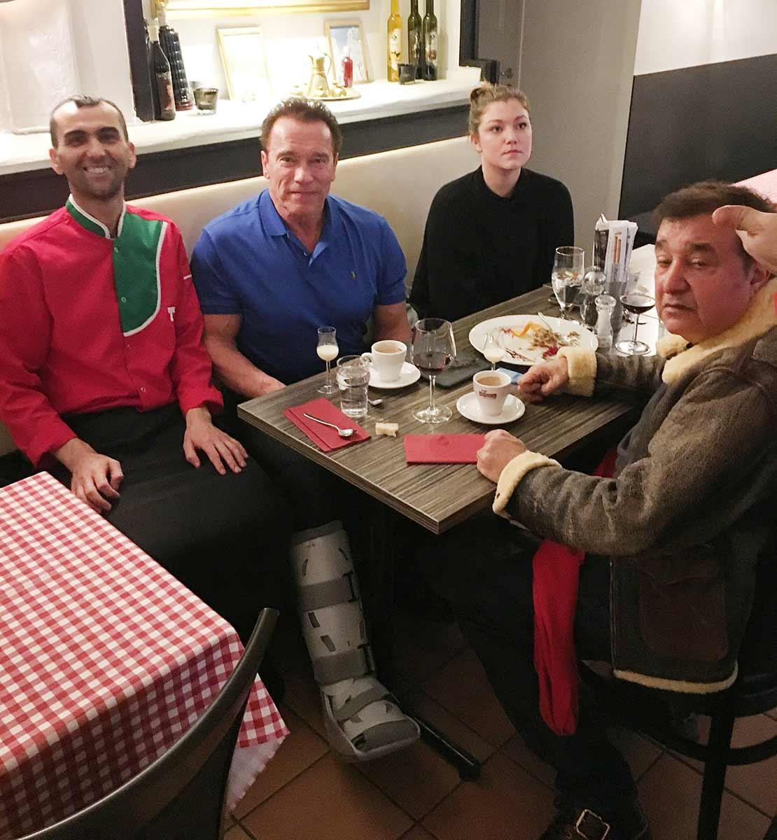 Arnold Schwarzenegger dök upp på en italiensk restaurang i Göteborg, med skadat ben.