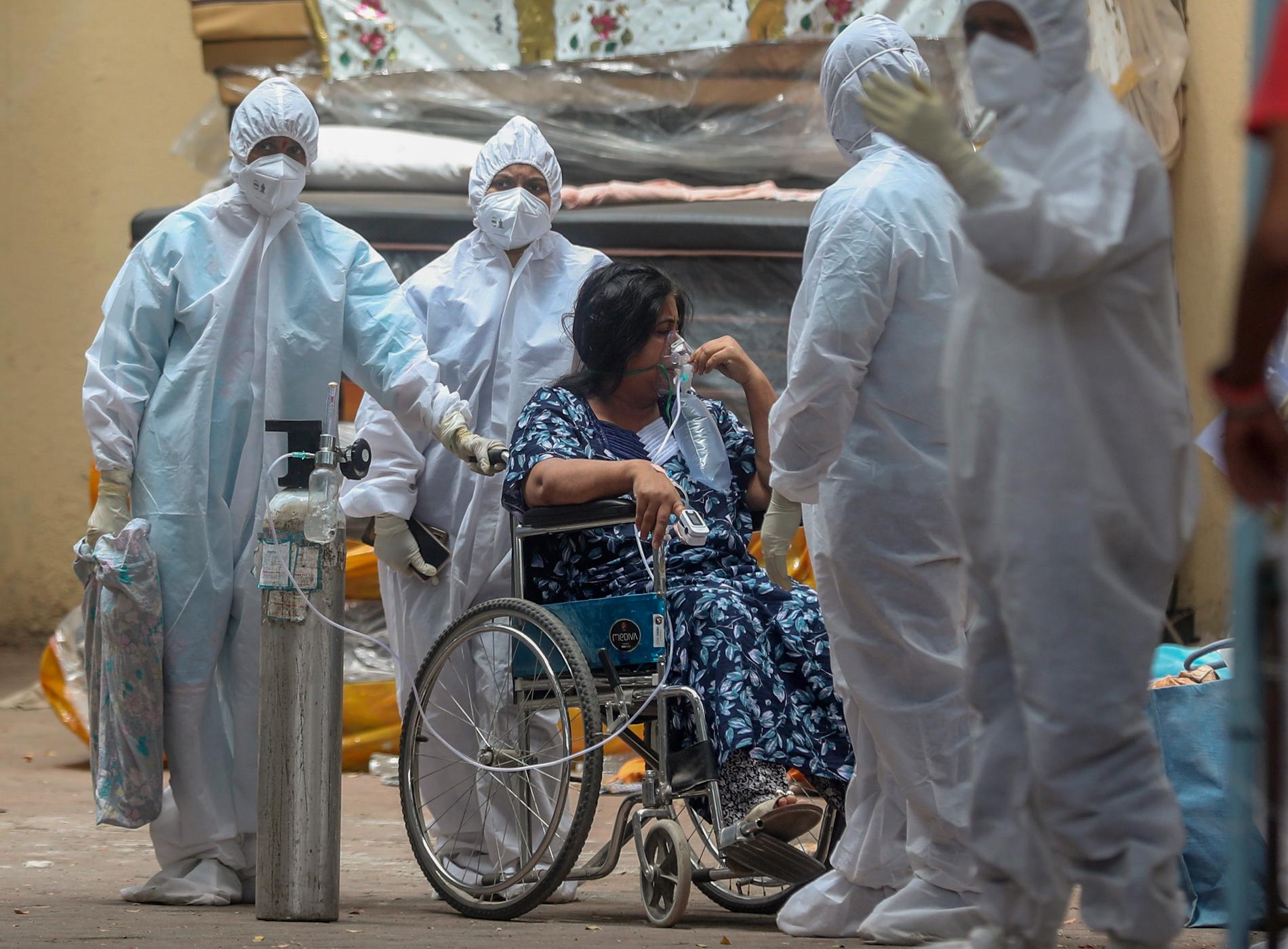 Vårdpersonal tar hand om en covidpatient i Bombay i Indien – där pandemin skenar utom kontroll.