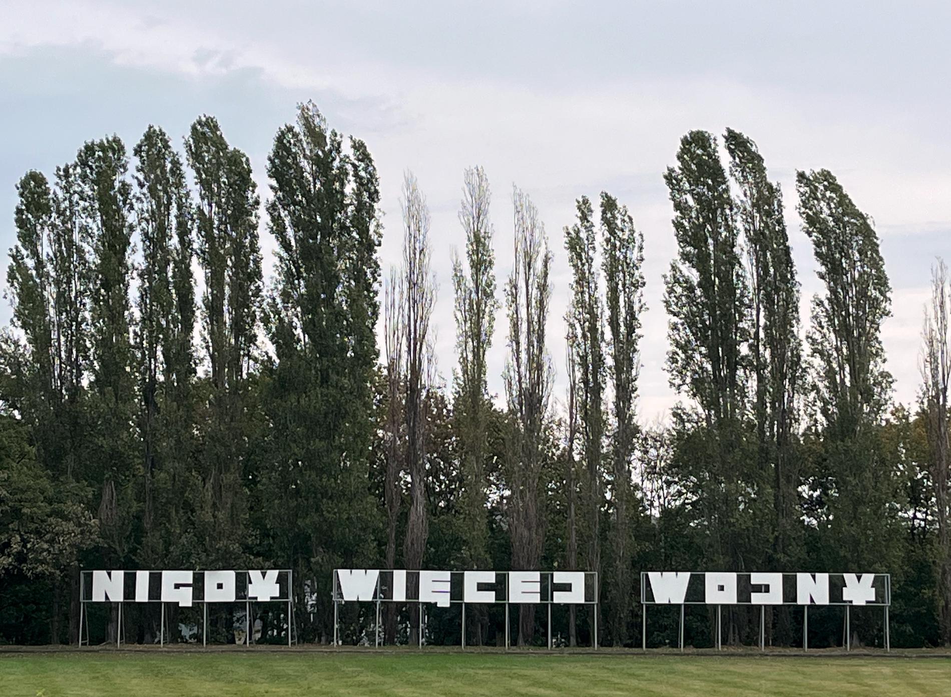 ”Nigdy Więcej Wojny”, polska för Aldrig mera krig, står med meterhöga vita bokstäver i parken i Westerplatte. 