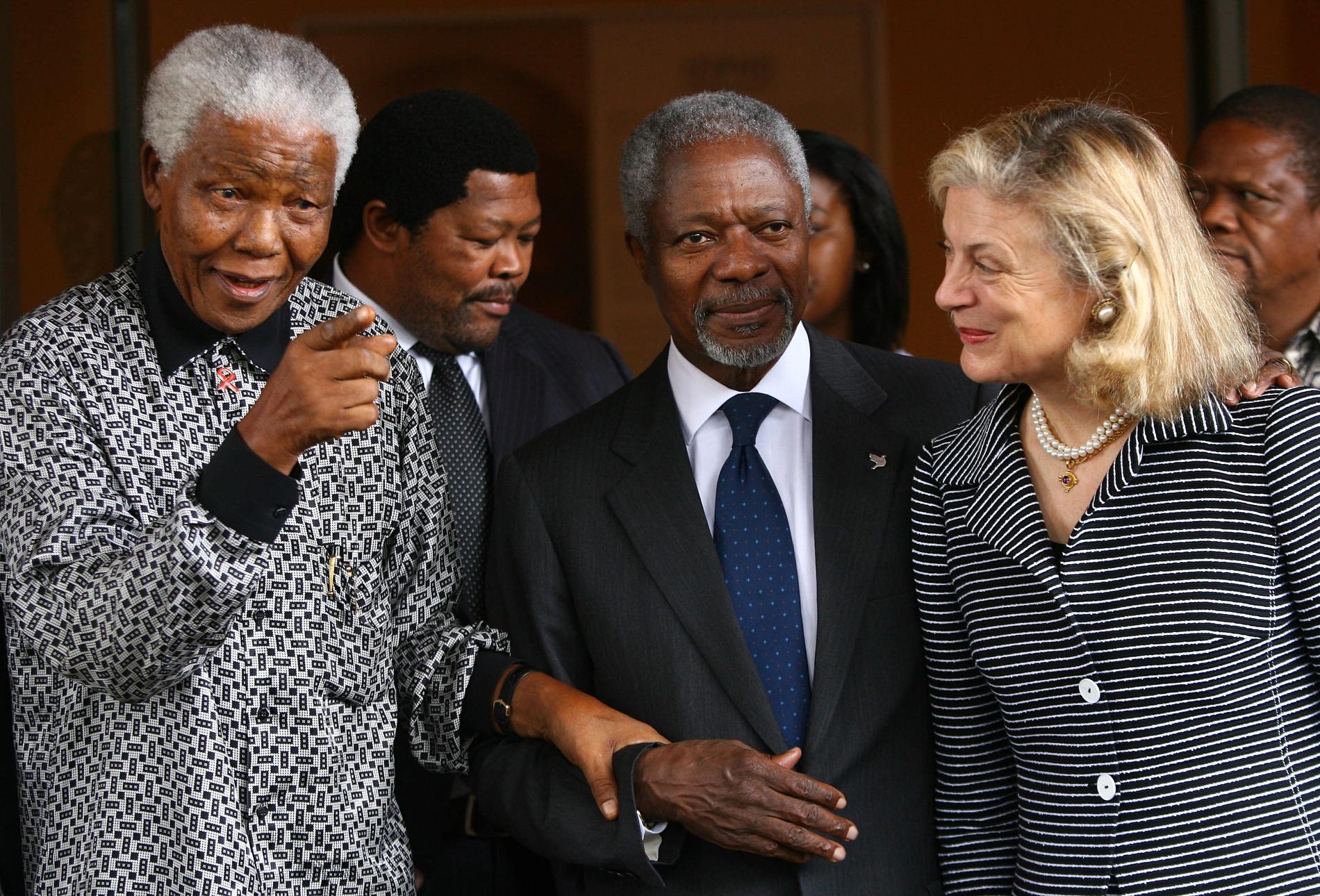 2006: Nelson Mandela, tidigare president för Sydafrika pekar mot journalister när han leder Kofi Annan och hans fru Nane Annan till ett möte på Mandela Foundation i Johannesburg.
