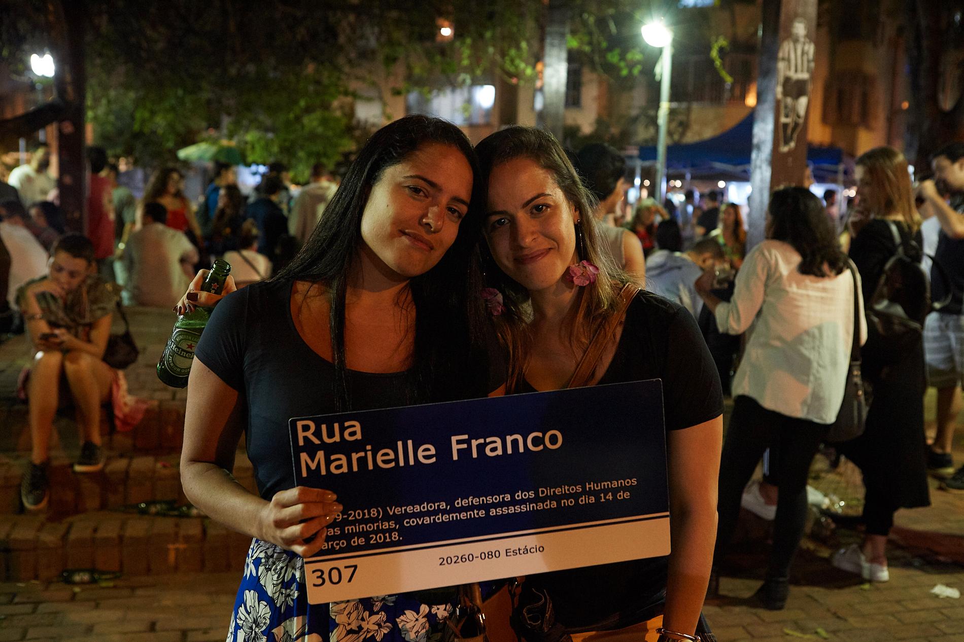 Mariana Souto, 31 (till vänster) och Elaine Martins, 33, håller upp en skylt med den i år mördade vänsteraktivisten och politikern Marielle Francos namn på.