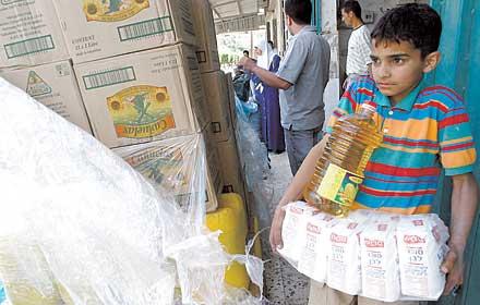 Svältpolitikens offer En palestinsk pojke i Jenin bär mat som donerats av arabiska israeler. Den ekonomiska bojkotten har urholkat den palestinska ekonomin och slagit hårt mot den fattiga befolkningen.