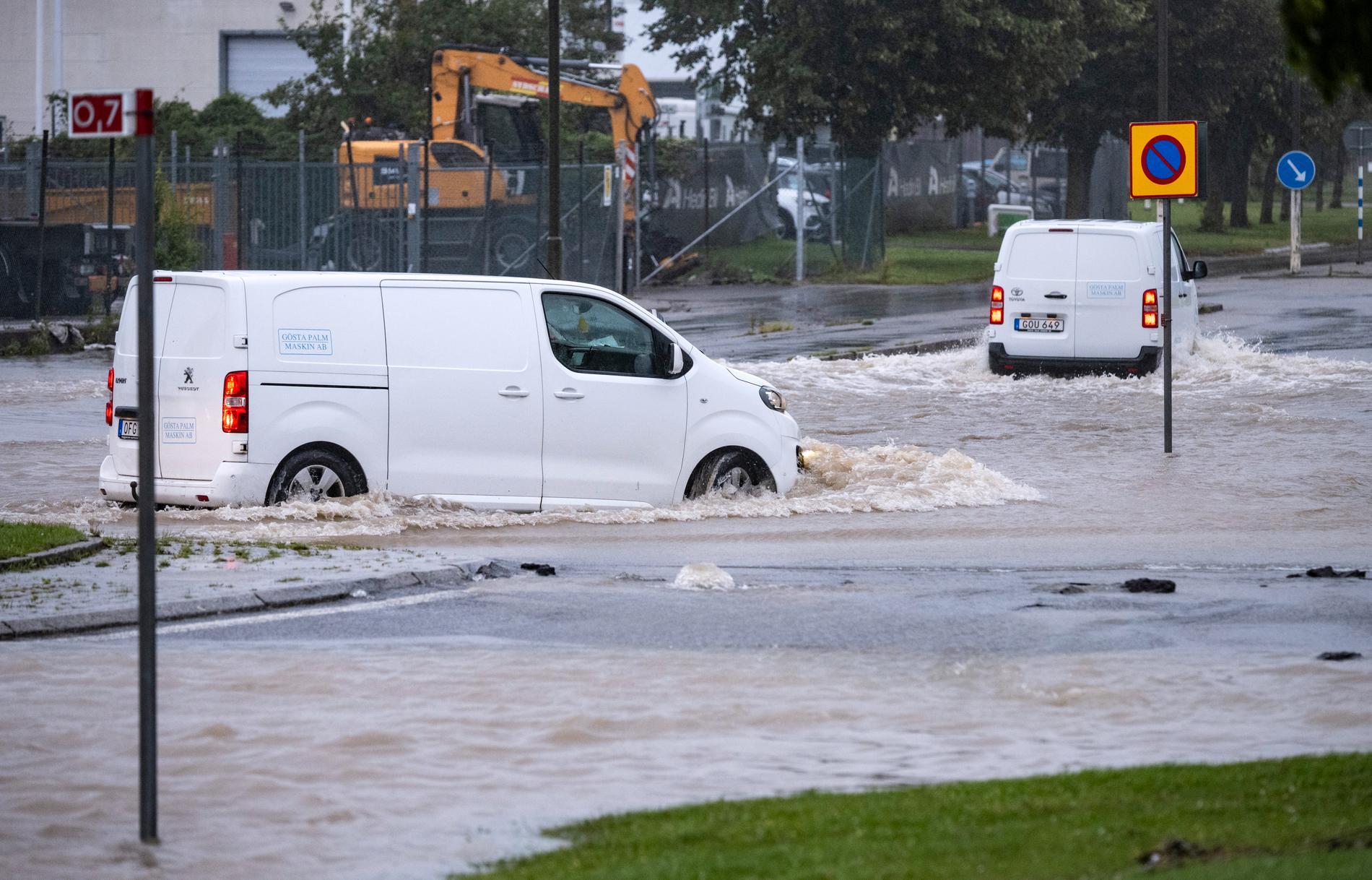 Bilar försöker ta sig genom en översvämmad rondell i Arlöv vid den avstängda översvämmade Västkustvägen E6 utanför Malmö på måndagsmorgonen.