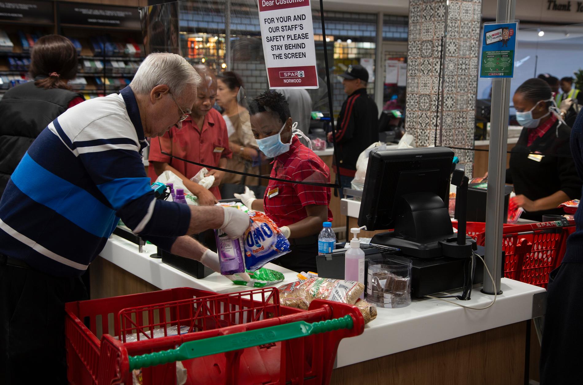 JOHANNESBURG, SYDAFRIKA En skärm är uppsatt som skydd mellan kunder och kassör på matbutiken Spar i Johannesburg på tisdagen.