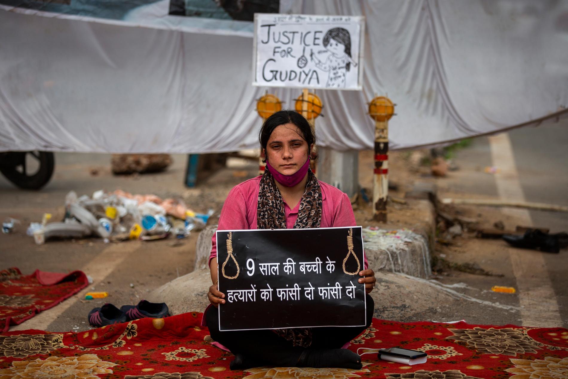 Aktivisten Tina Verma håller en skylt med texten "häng nioåringens mördare" i indiska Delhi.