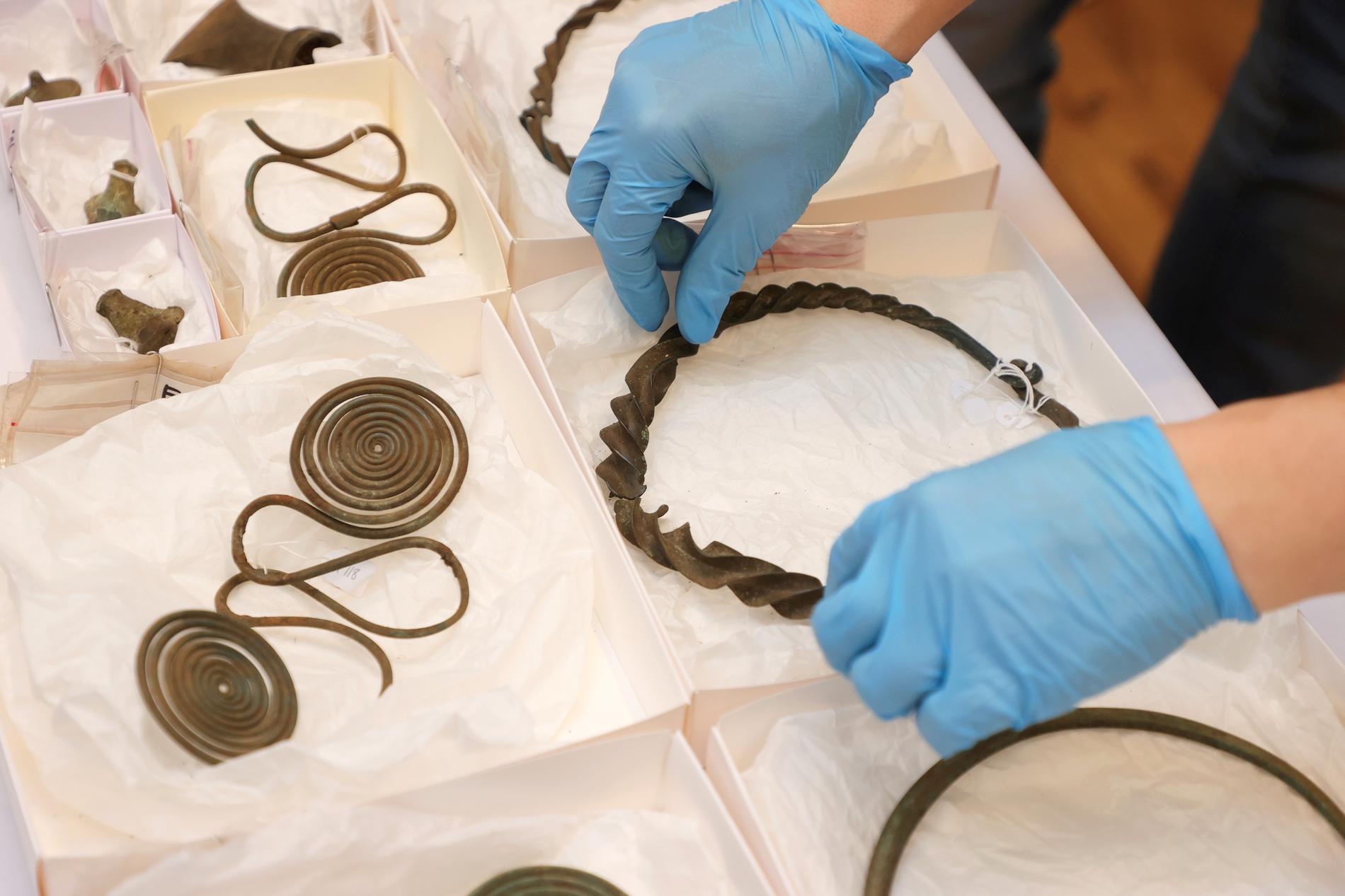 Halsringar, fotringar, kedjor och andra föremål från yngre bronsåldern har hittats vid en arkeologisk undersökning söder om Alingsås