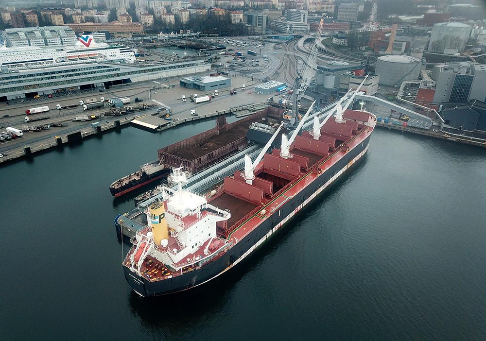 Bulkfartyget PHOENIX RISING ligger i Värahamnen och lossar flis från sydamerikas regnskogar som ska användas i värmeverket för att kunna värma frusna stockholmsbor.