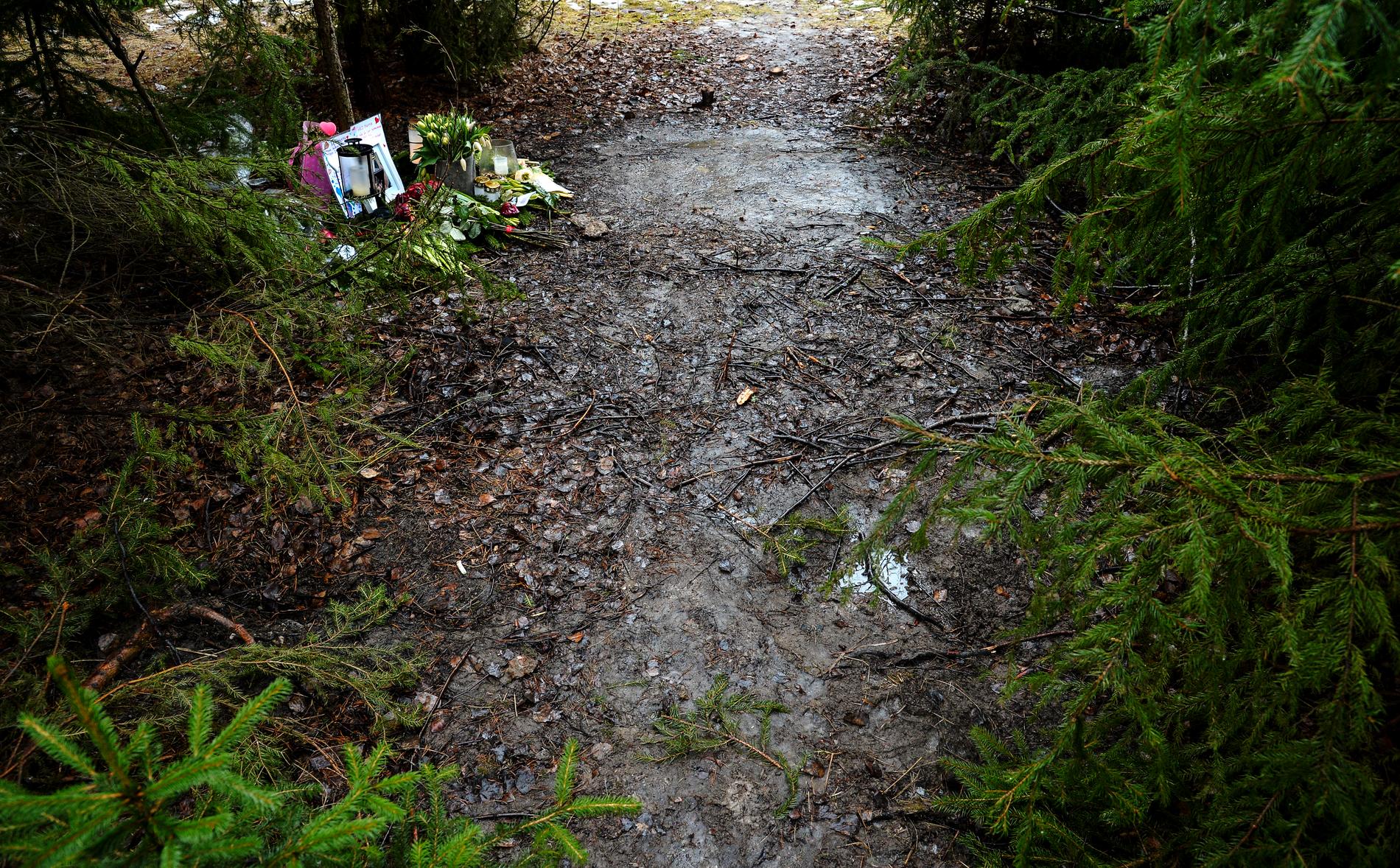 Ett ljus och ett hjärta på vägen intill det skogsparti utmed E4:an i Upplands Väsby där en 29-årig kvinna hittades död 2016. Arkivbild.