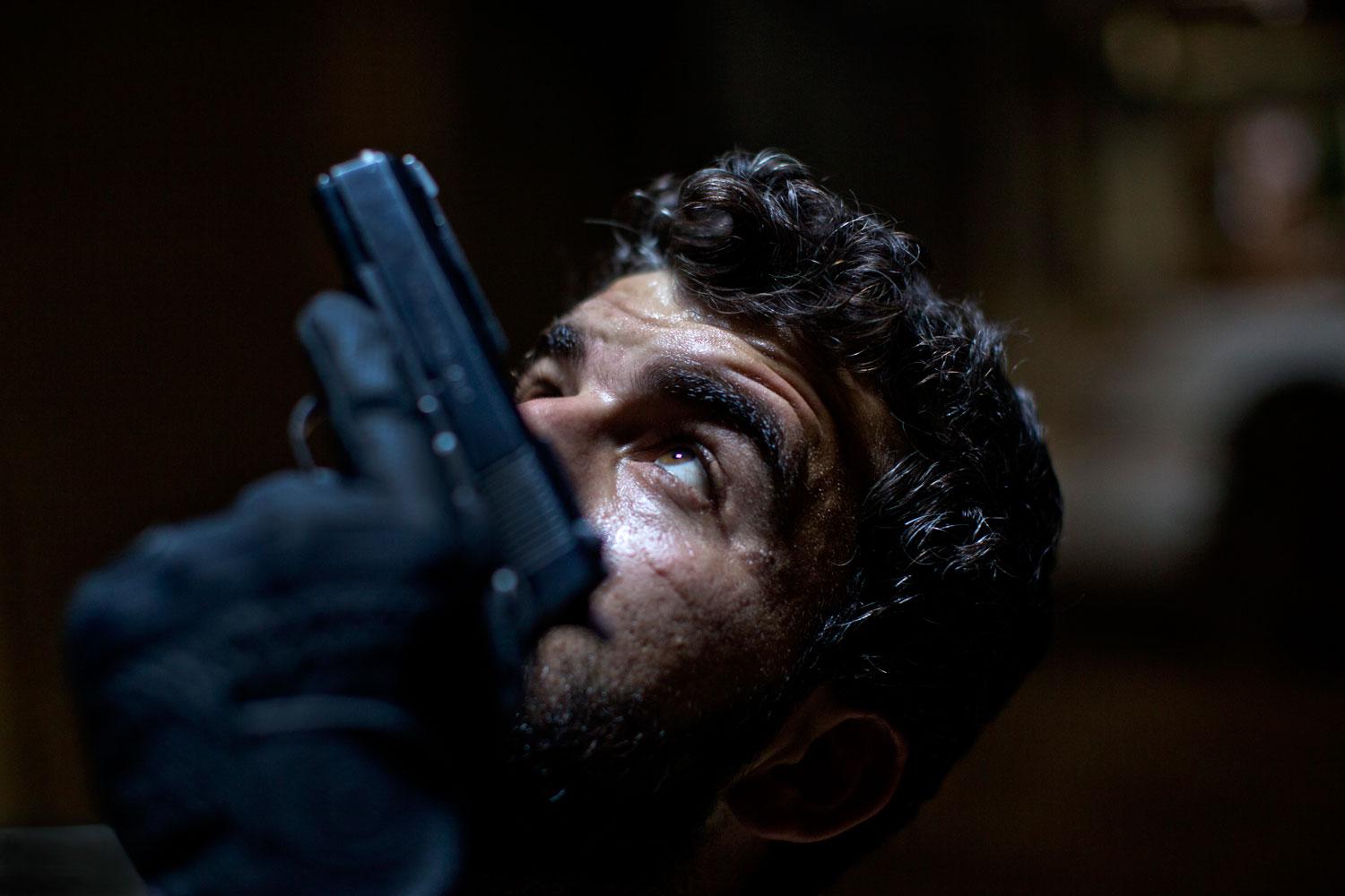 Abdullah Alyasin, soldat i rebellarmén, på utkik efter krypskyttar i Aleppos gamla stad.