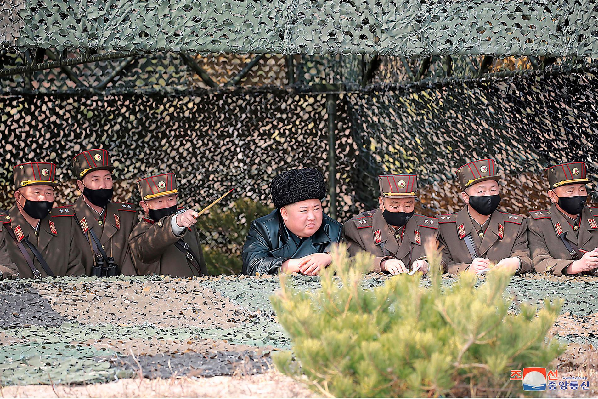 Bild från den nordkoreanska nyhetsbyrån KCNA, som enligt uppgift föreställer Nordkoreas diktator Kim Jong-Un när han följer en militär tävling i Nordkorea, utan skyddsmask. Arkivbild.