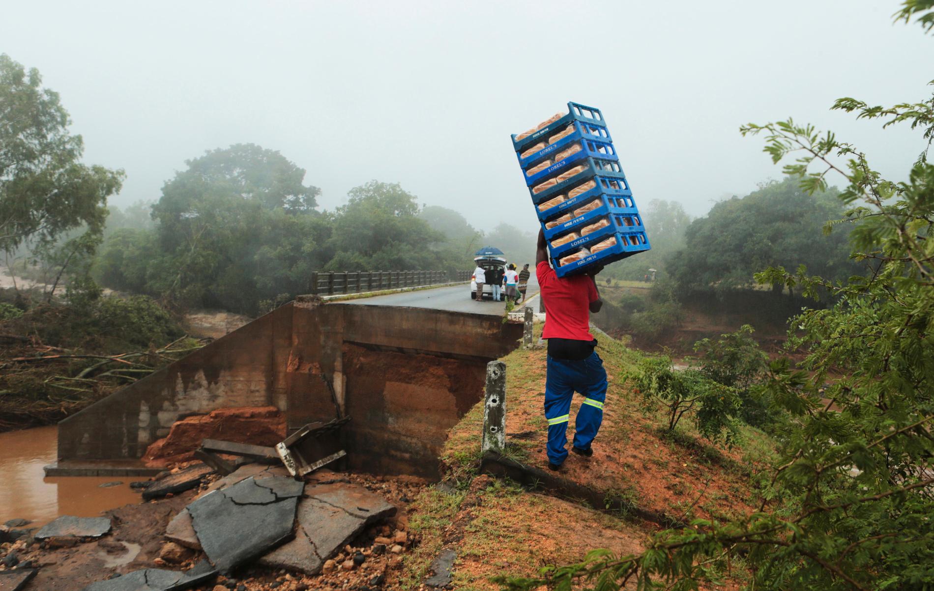 En man tar sig över en kollapsad bro i Chimanimani i Zimbabwe. Landets president har kallat cyklonen den värsta infrastrukturella katastrofen i Zimbabwes historia.